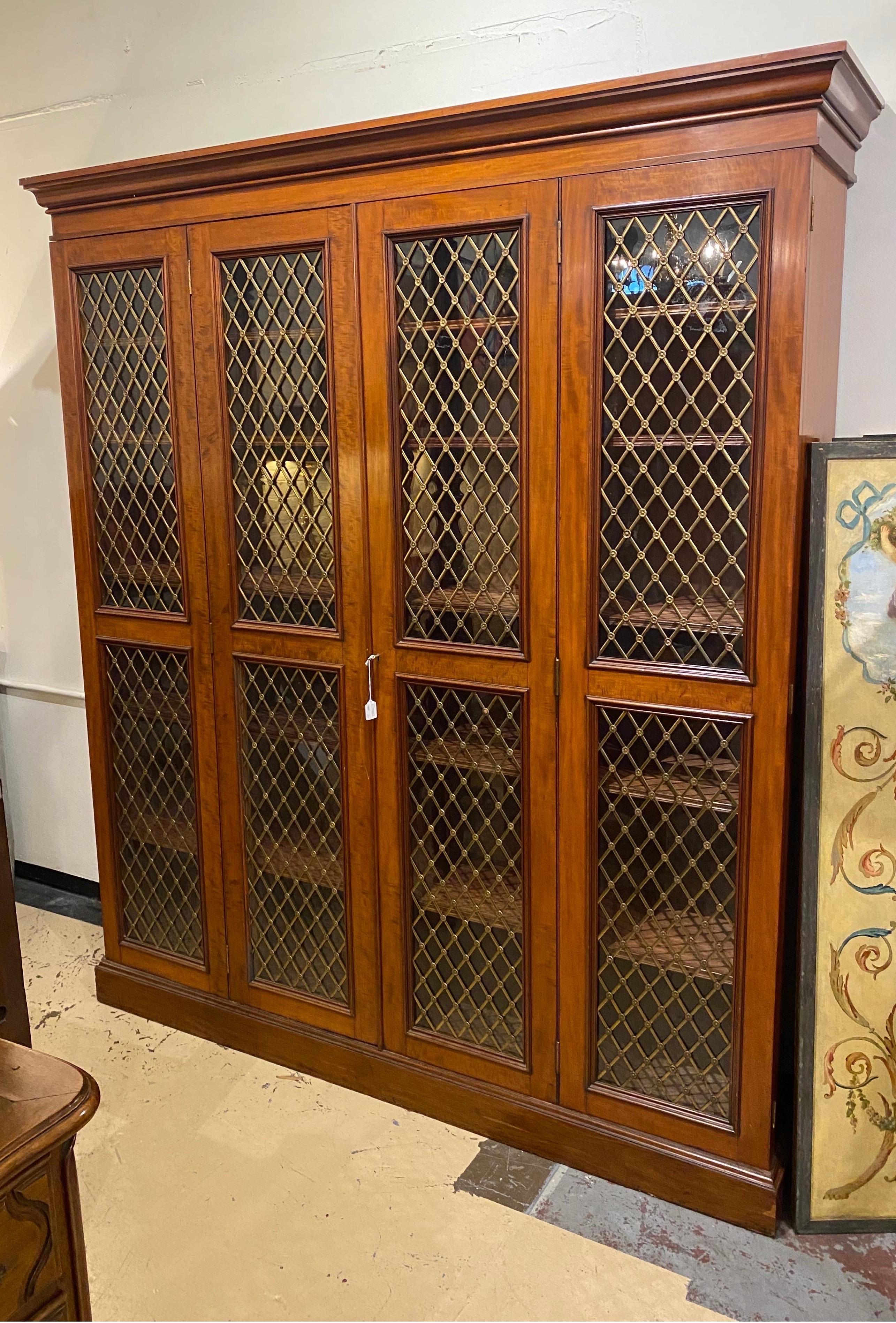 Great 19th century English regency bookcase or gun case with double folding doors and adjustable shelves. The bookcase is set on a plinth base and has 4 doors that fold outwards. The shelves are fully removable and could easily be altered to support