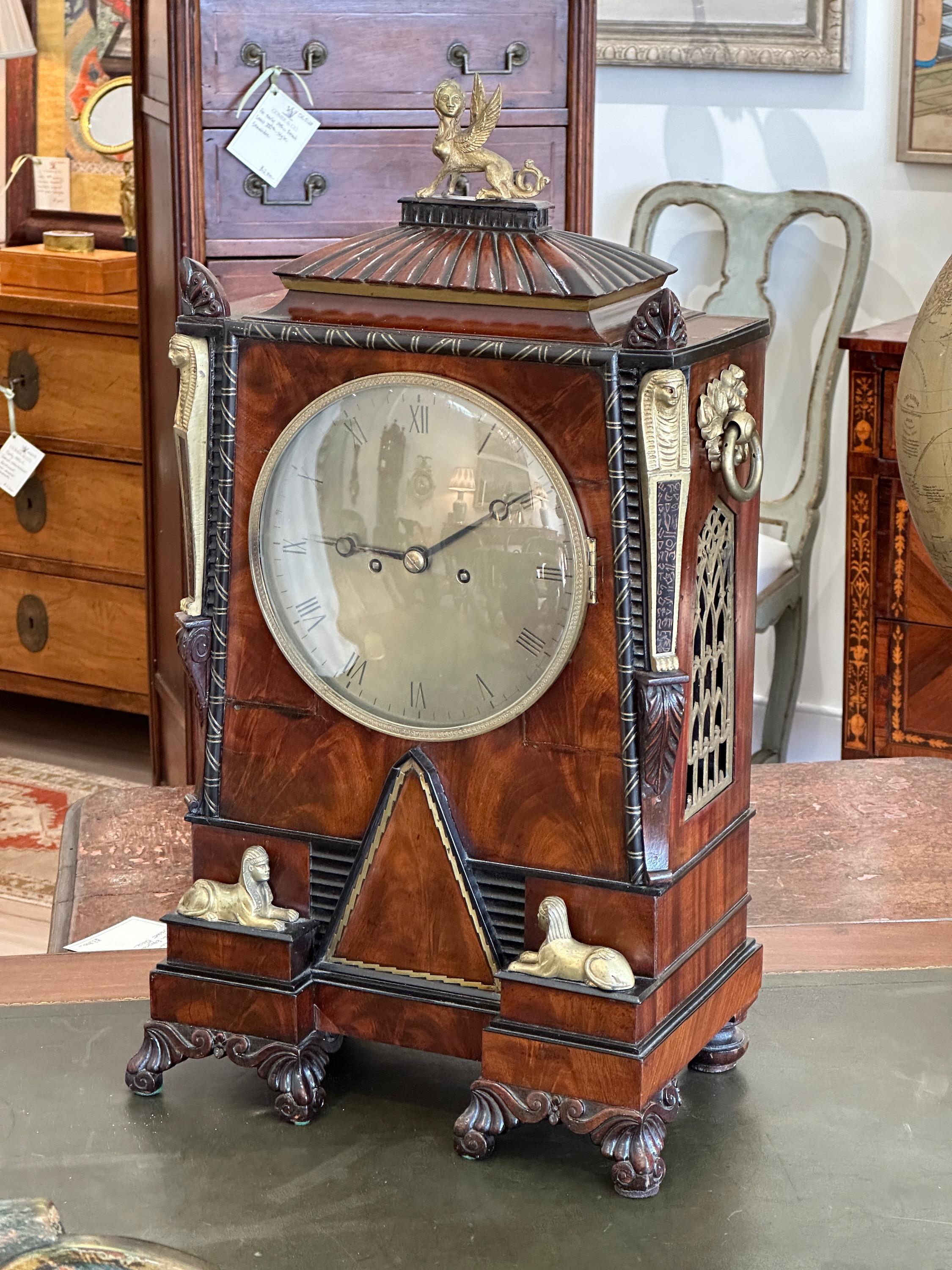 A large and impressive early 19th C. English Regency period Egyptian Revival bracket clock. The mahogany case is ornamented throughout with sphinx, obelisks, hieroglyphics and other Egyptian themes.