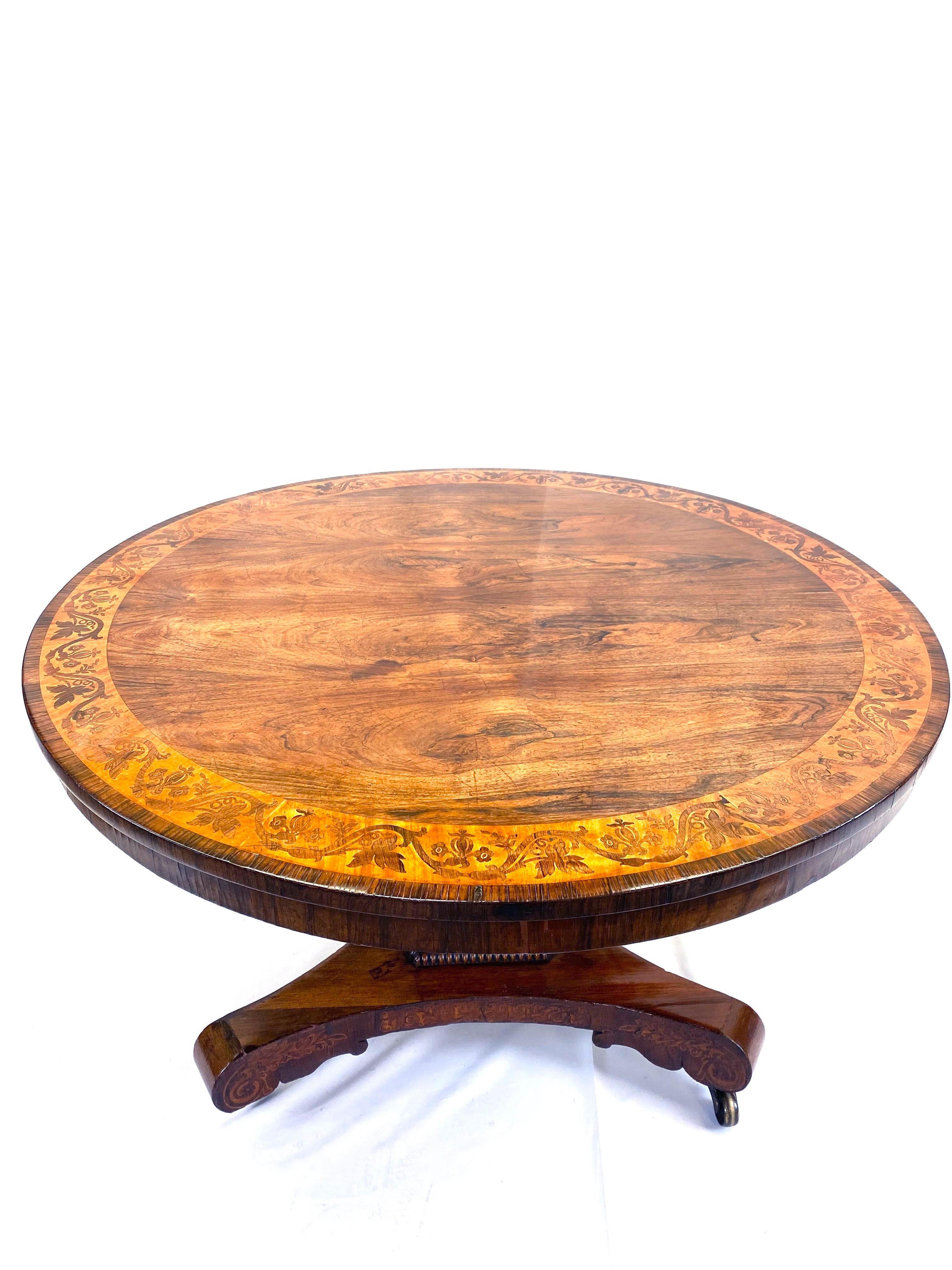 Gorgeous English Regency period tilt-top breakfast table with rosewood marquetry inlay banding. We recently French polished this table. It is in excellent condition with original hardware.
  