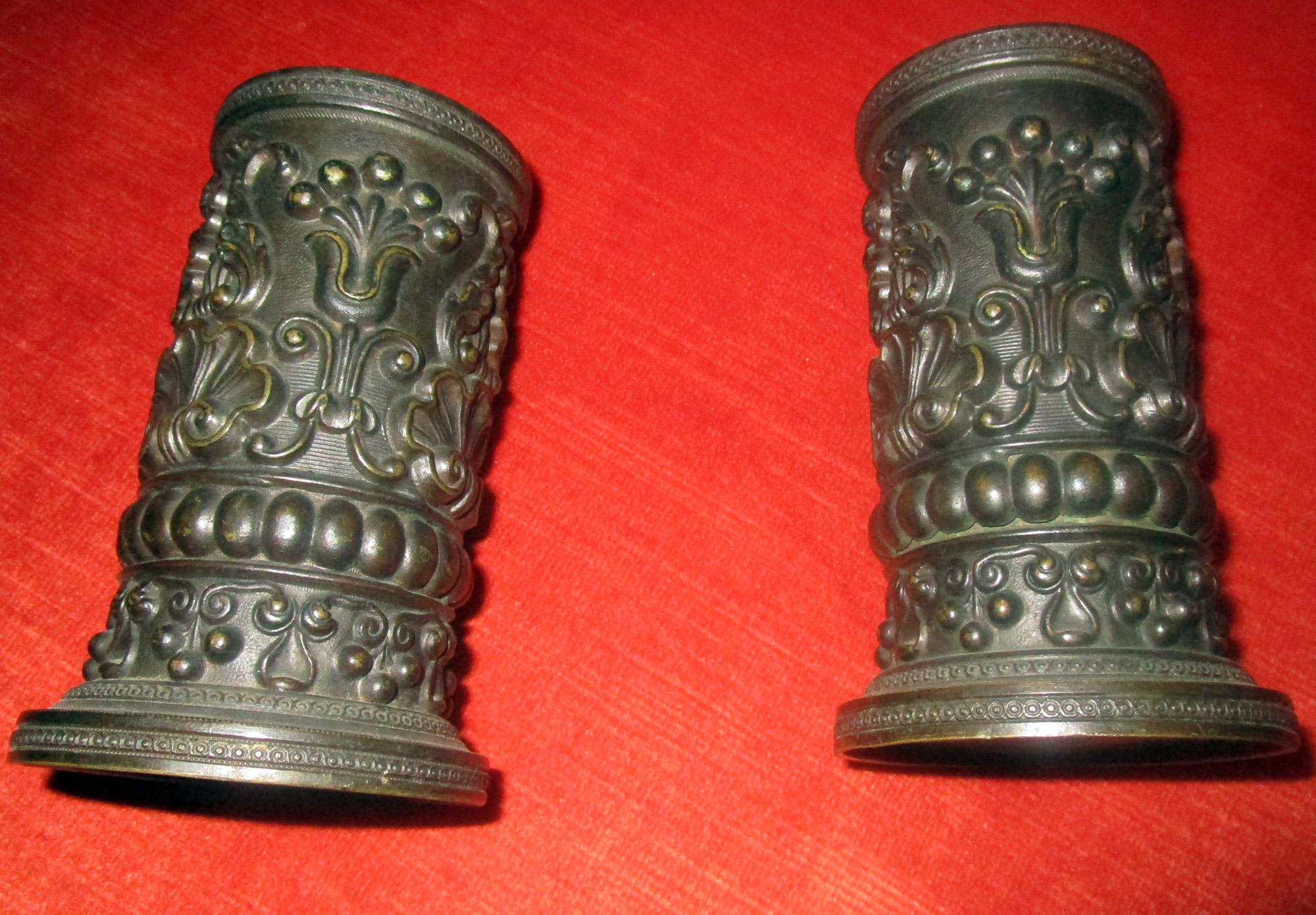 Pair of English Regency style embossed bronze spill vases in a rare small size. The workmanship is incredible and features Classic shell, lyre and floral detail. Rolled and soldered with one seam visible only from the inside, they are truly little