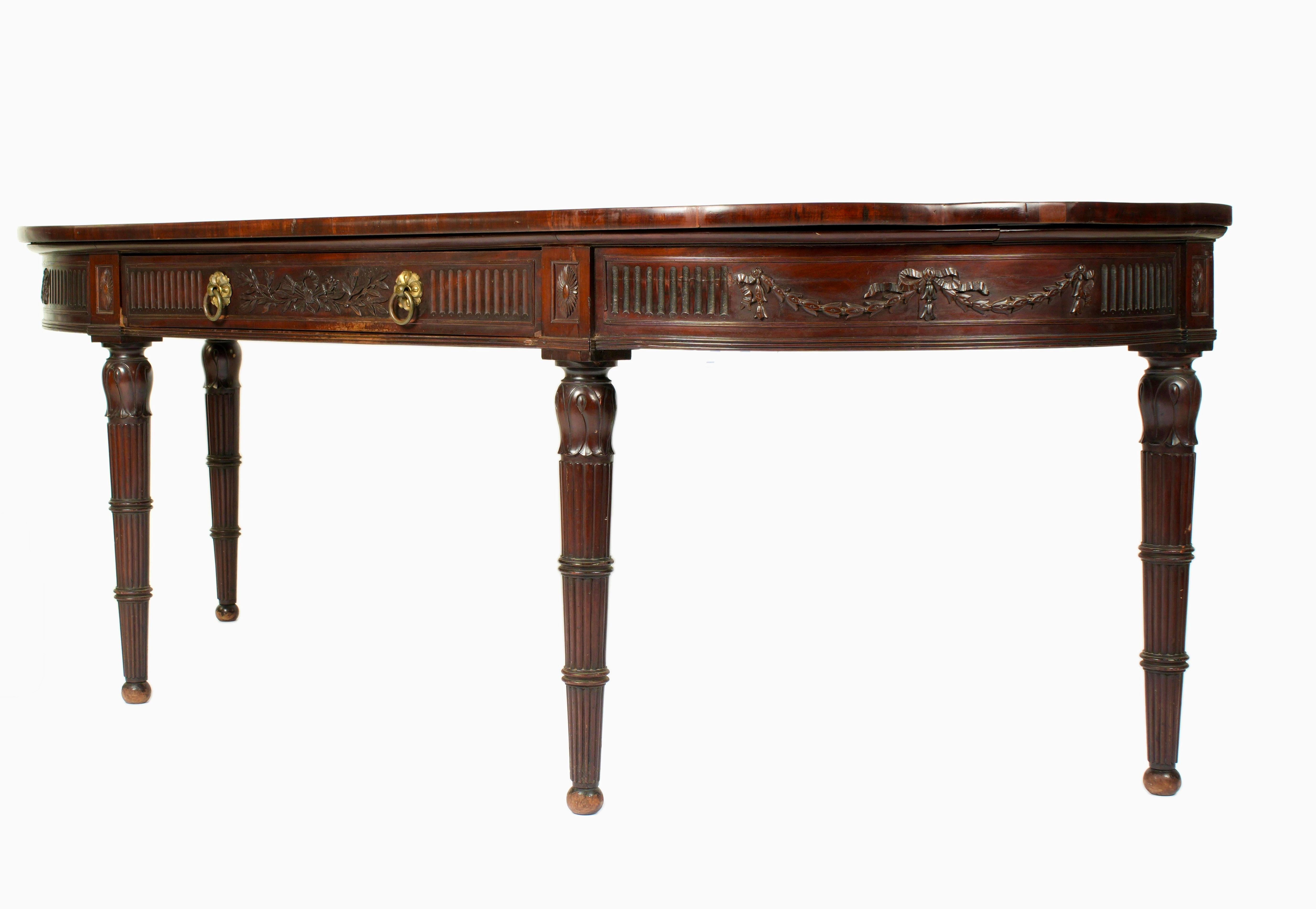 Monumentale table de service / console en acajou de style Régence anglaise. Le plateau est en forme de D avec un bord arrondi et des extrémités arquées. Il repose sur un tablier sculpté de guirlandes de fleurs et de panneaux de rubans. Tiroir