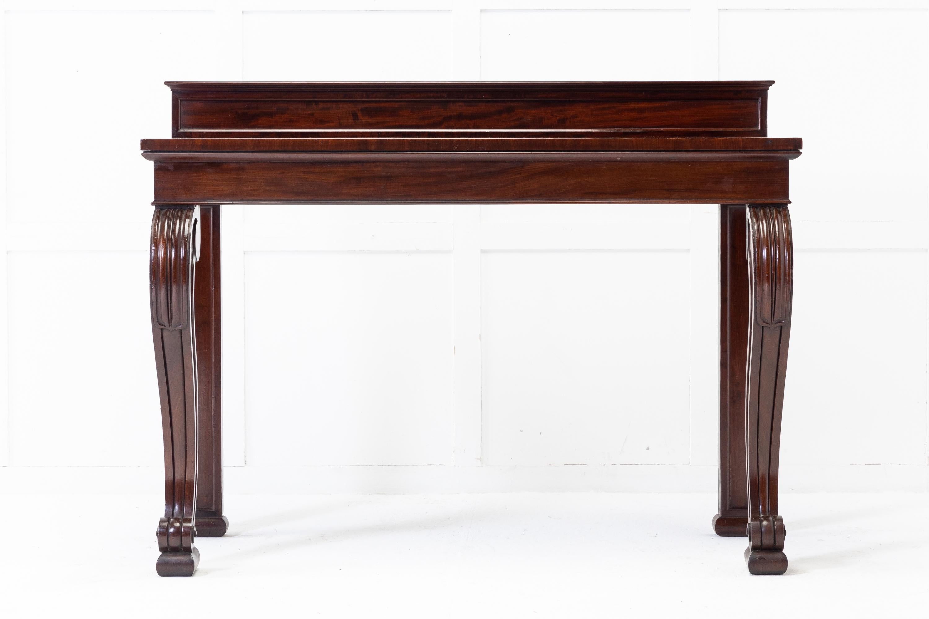 Early 19th century English Regency mahogany console table with rectangular top and small, shallow panelled up-Stand at the back. Supported by exaggerated scrolled front legs and panelled back legs with squashed feet.

A wonderfully shaped and