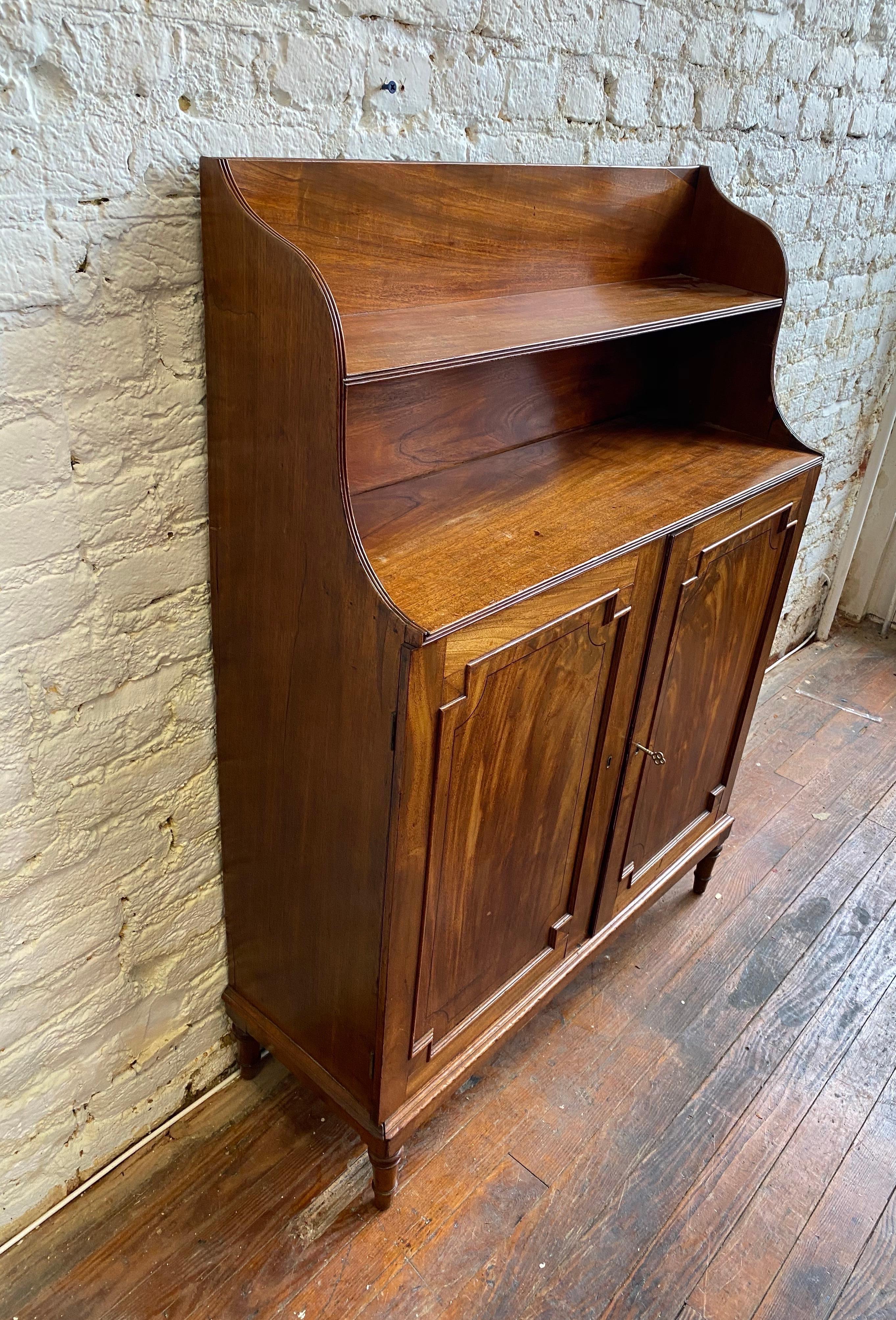 Great size 19th century English Regency flame mahogany chiffonier bookcase on turned feet with framed panels. 


Would make a great bar.