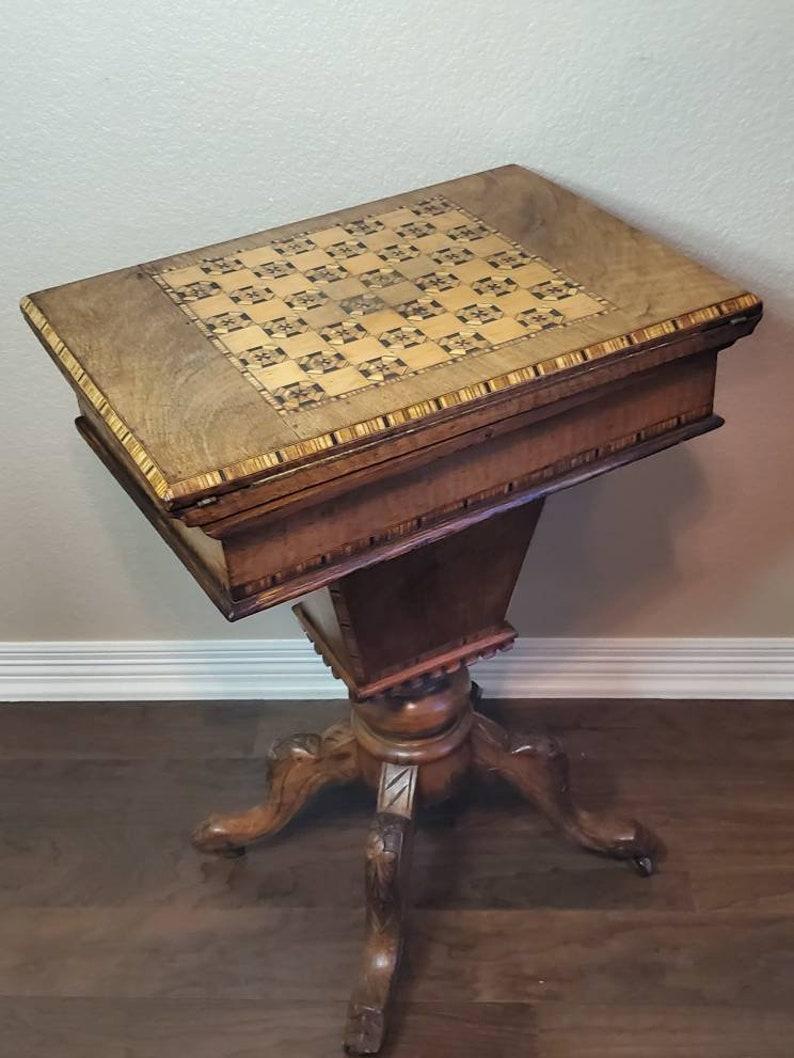 A fine quality, exquisitely handcrafted, antique English games / sewing table finished in Regency taste. Born during the third quarter of the 19th century, featuring stunning burl walnut, delicate marquetry, banding inlay and intricate checkered