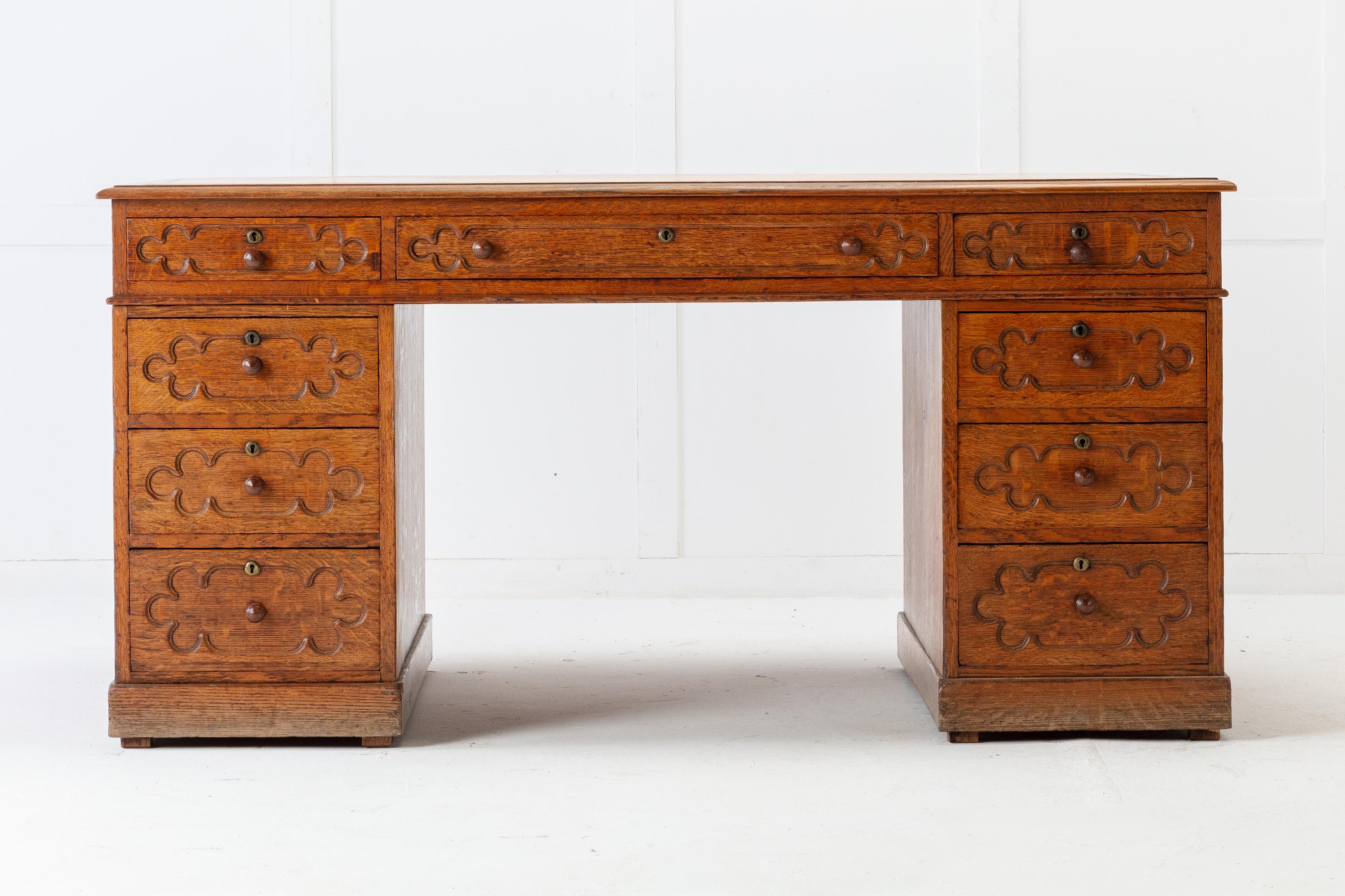 19th century English Regency, oak partners desk with very simple gothic decoration. Three drawers across the top and a quality, old, beige tooled leather writing surface. Rising from a plinth base. Drawers to one side and cupboard doors to the