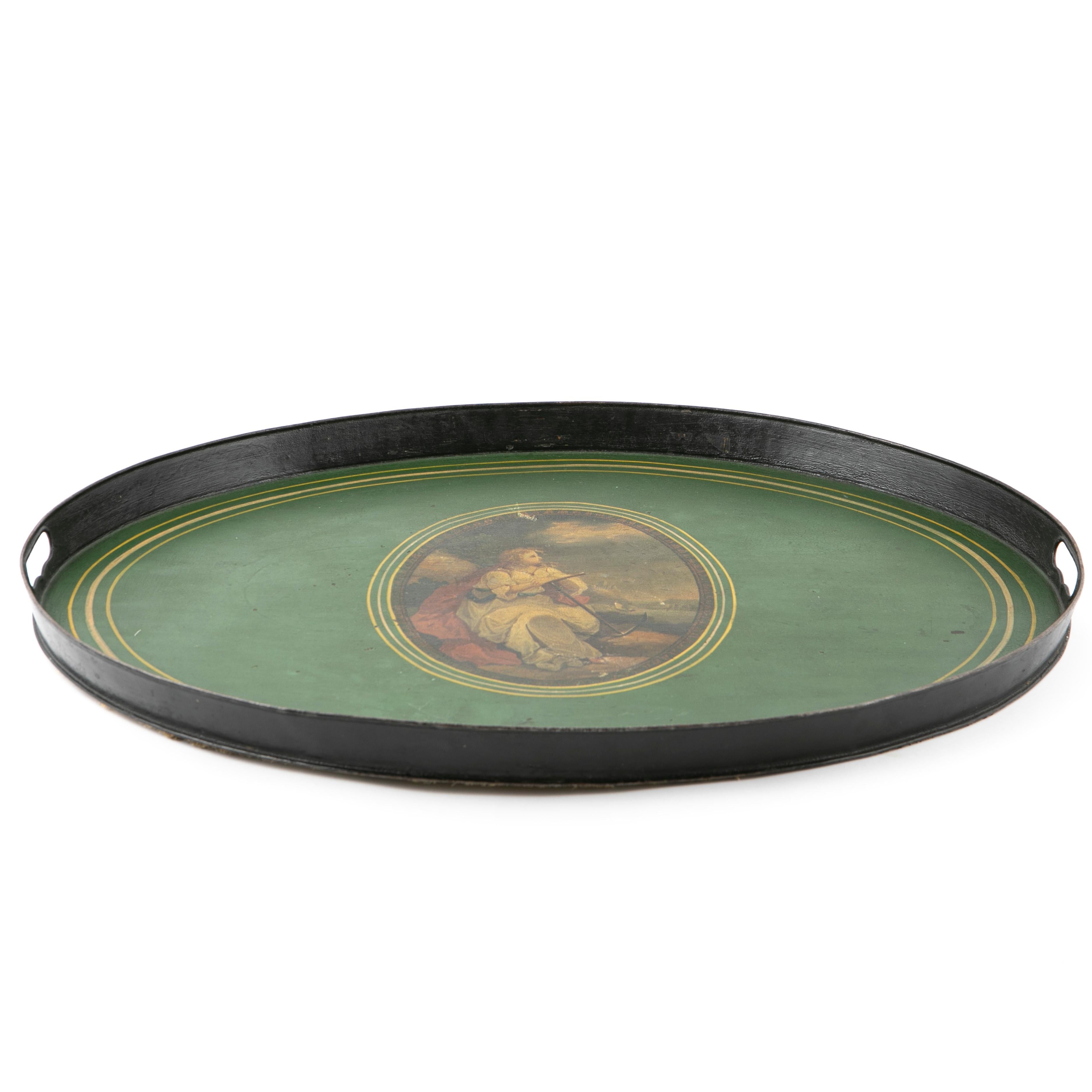 Large English early 19th century oval tole tray.
Metal beautifully painted with an oval center medallion with coastline scene of a young woman with anchor scouting out to sea. Standing rim with pierced side handles.
The tray table is in excellent