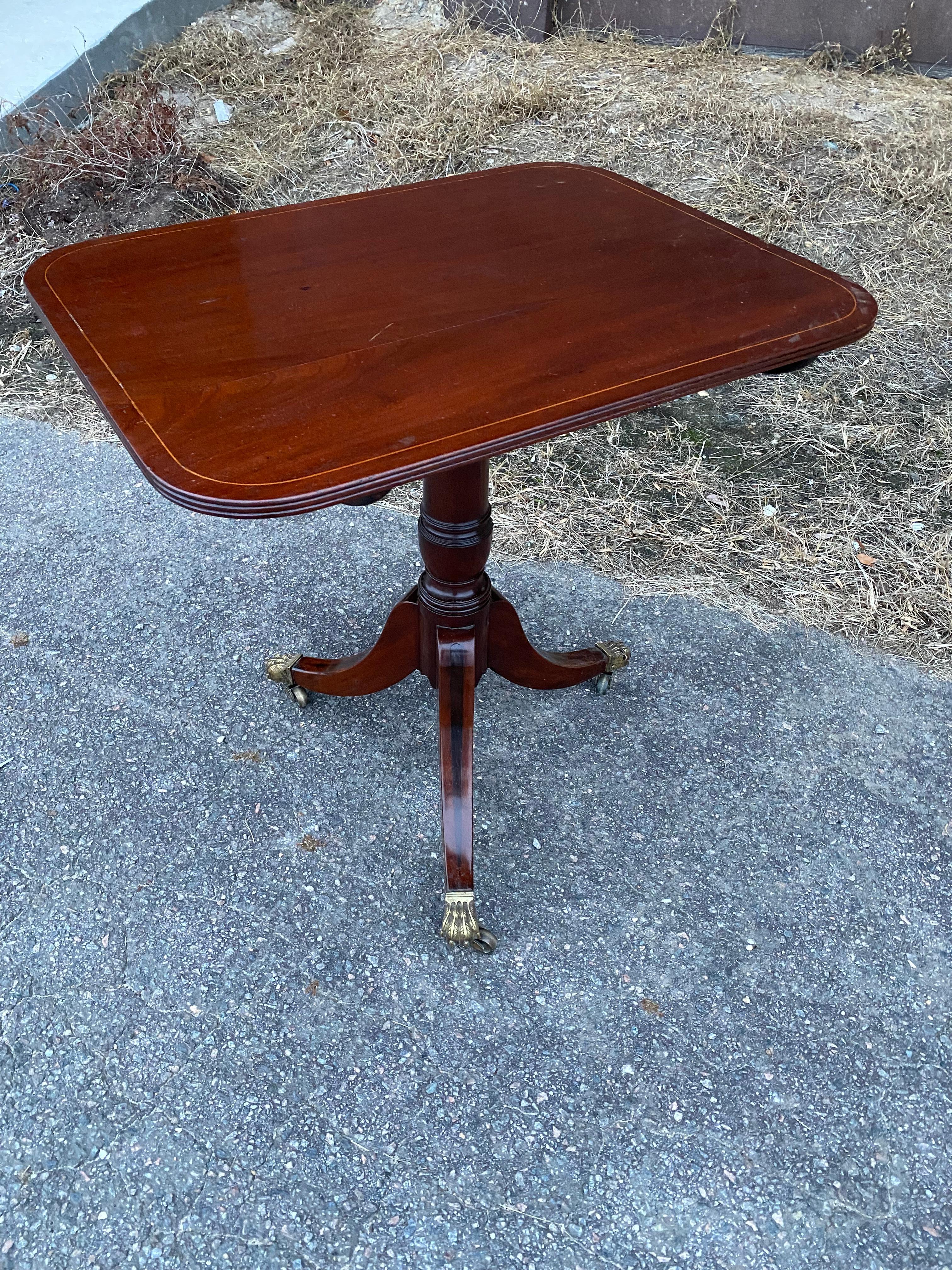 Great little 19th century English Regency tilt top mahogany side table with string inlaid top, ebony inlaid legs and paw foot castors.
