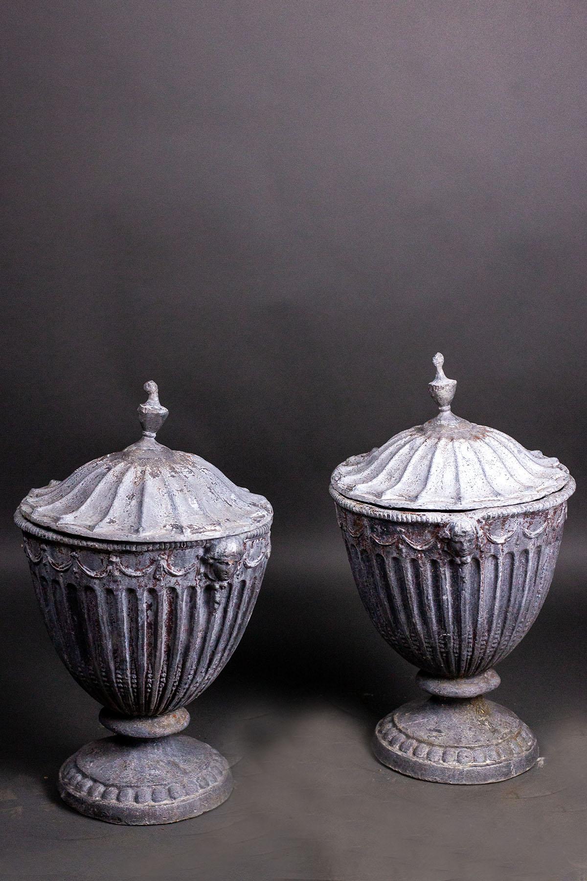 fleurdetroit offers for your consideration, a pair of 19th century, English Regency period, lead urns with removable lids. Vase forms are heavily decorated with fluting and classical garlands. Both exhibit a patina that only is manifested through