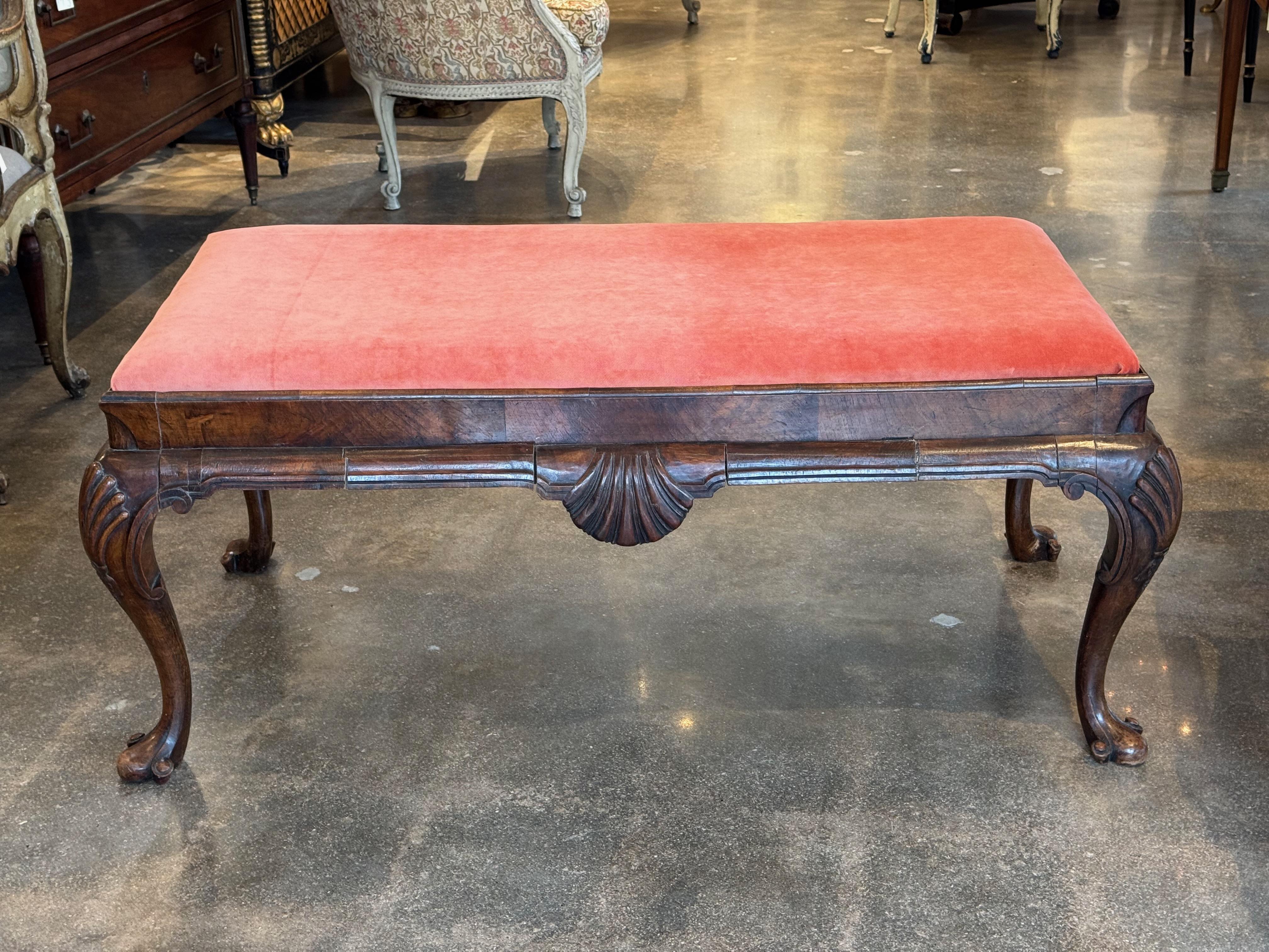 Banc Regency anglais du début du 19e siècle en acajou, présentant un motif de coquille richement sculpté sur le tablier avant et des pieds cabriole bien formés se terminant par des pieds pad. L'assise rembourrée est recouverte d'un velours doux de