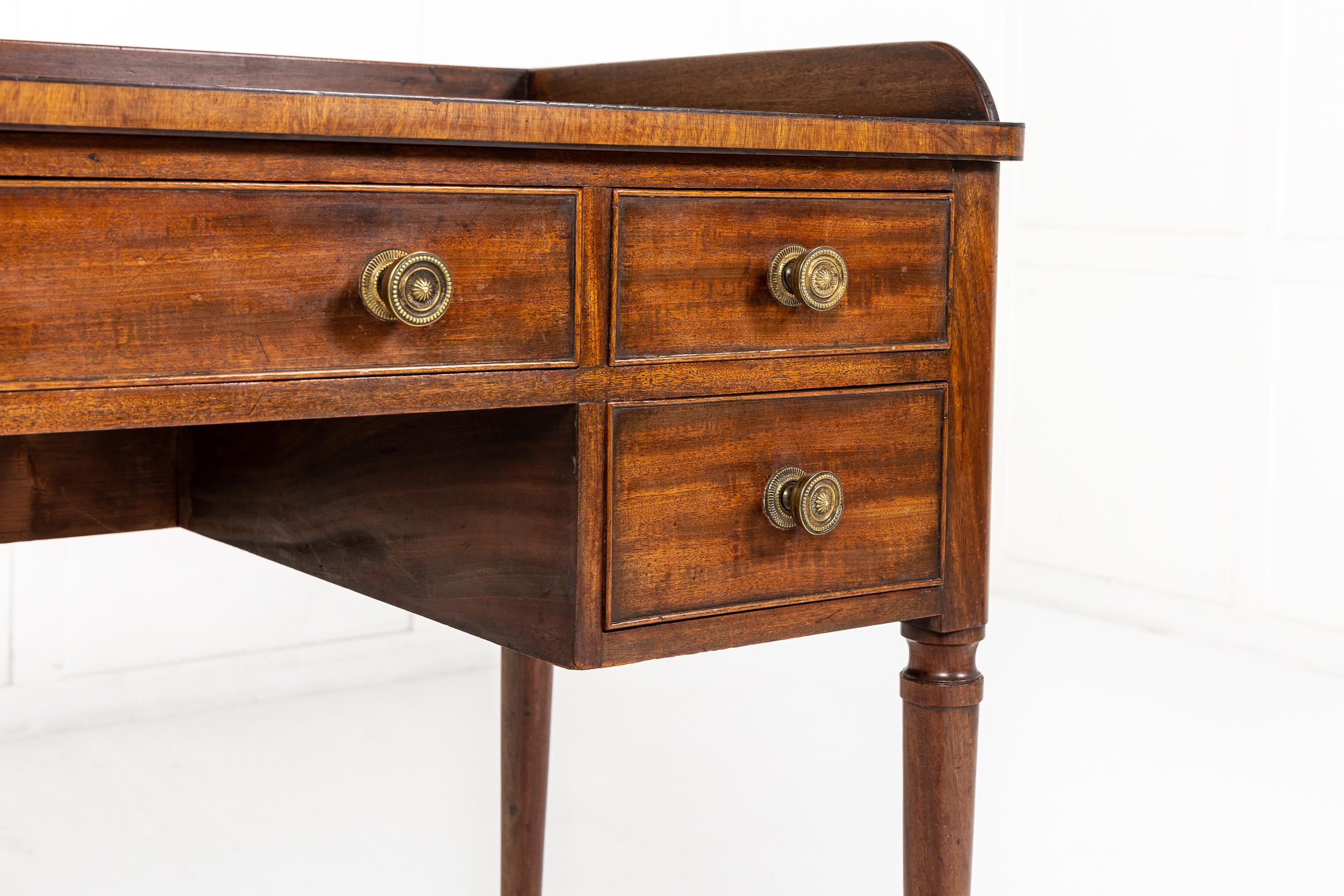 A good quality 19th century English Regency mahogany dressing table/desk, in the manner of 'Gillows' of Lancaster. Having a galleried top with moulded edge and fine ebony stringing, with an arrangement of five moulded edged drawers below, having