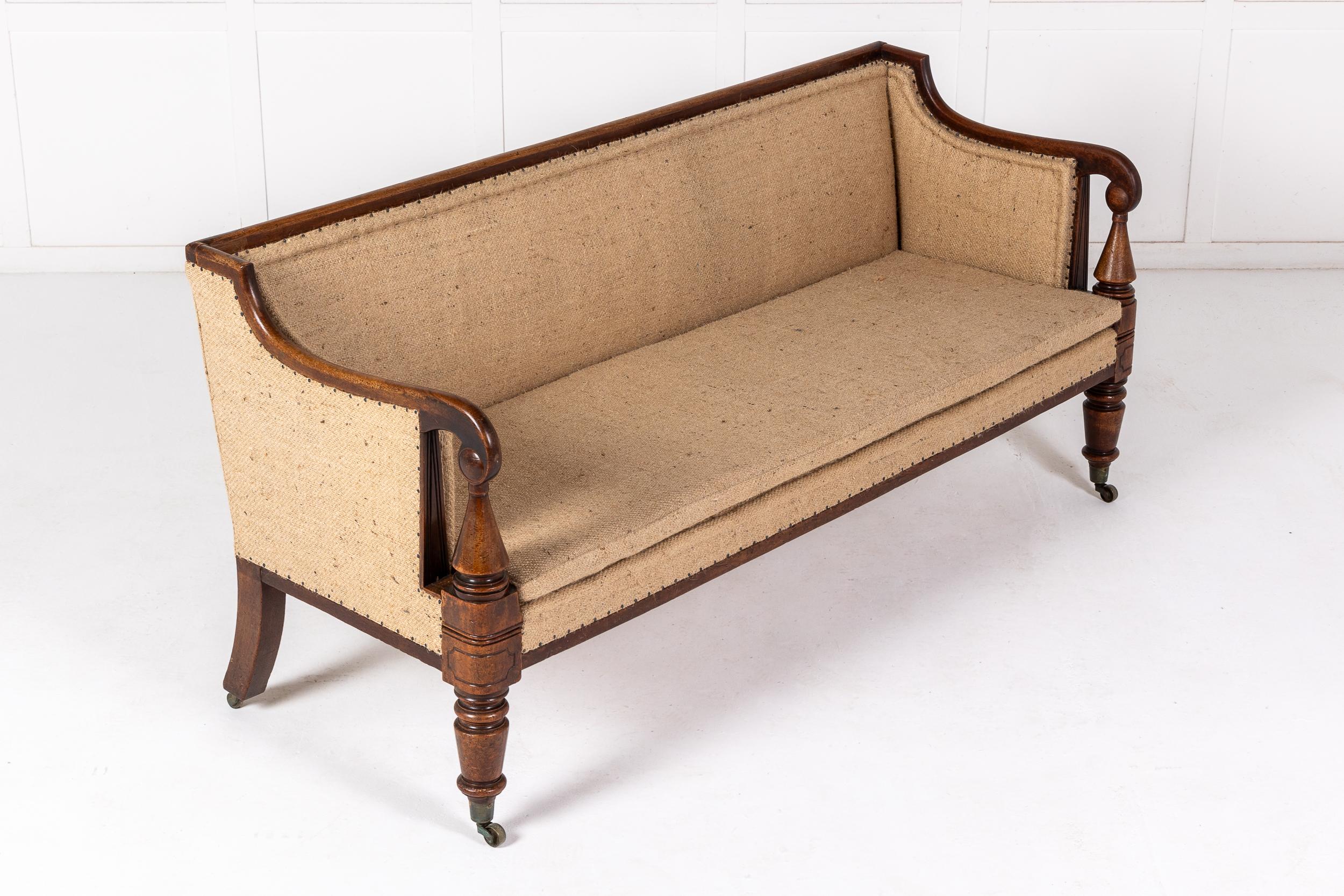 A Quality English Regency Period Mahogany Sofa or Settee c.1820.

Of broadly rectangular form, and substantial quality, with a straight back rail, this practical piece has in-scrolling arm rests supported on turned conical columns supported by