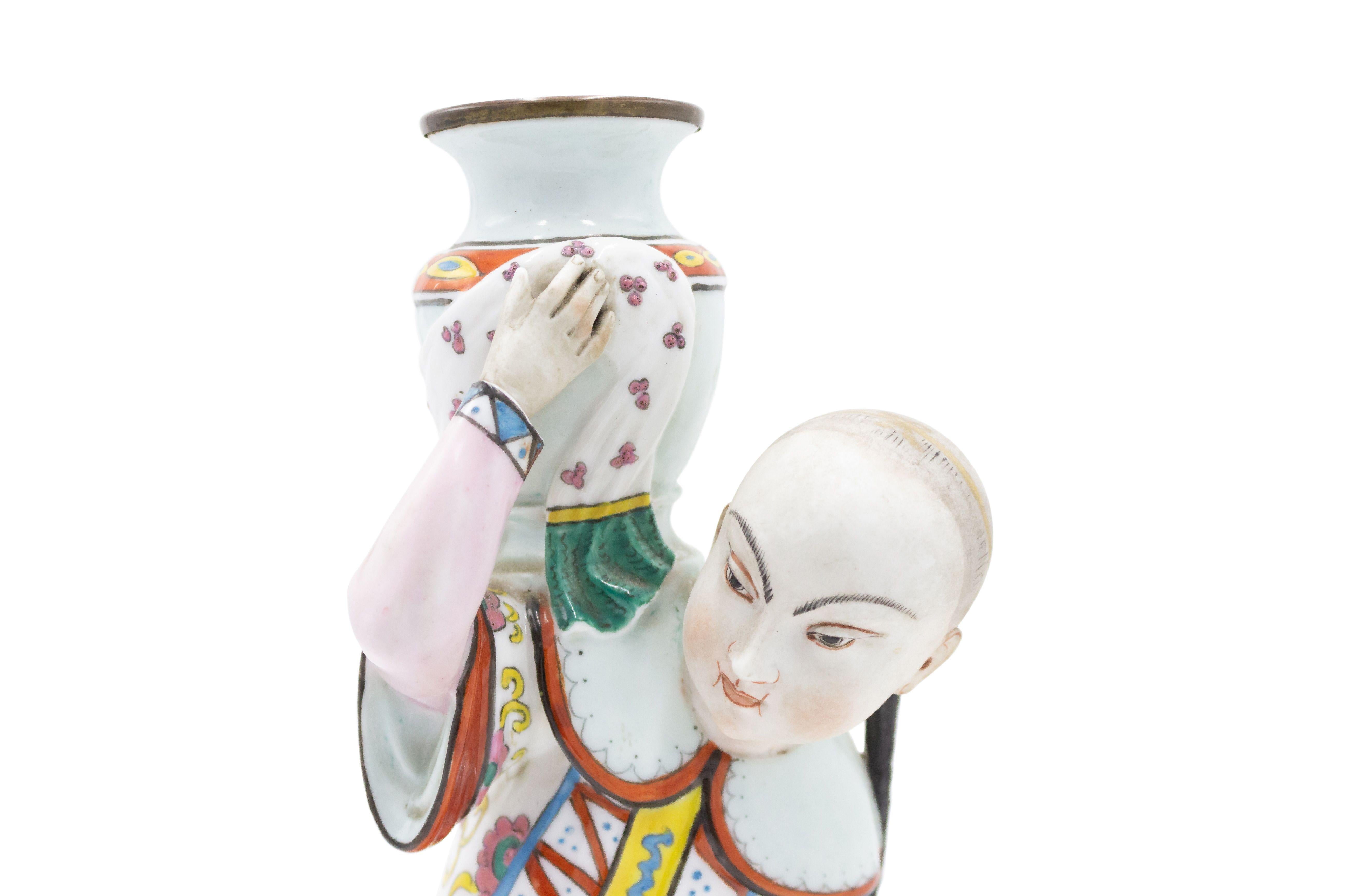 Englischer Porzellan-Kerzenhalter im Regency-Stil (spätes 19. Jahrhundert) mit Ormolu-Montage in Form von knienden chinesischen Figuren, die eine Urne halten.
 
