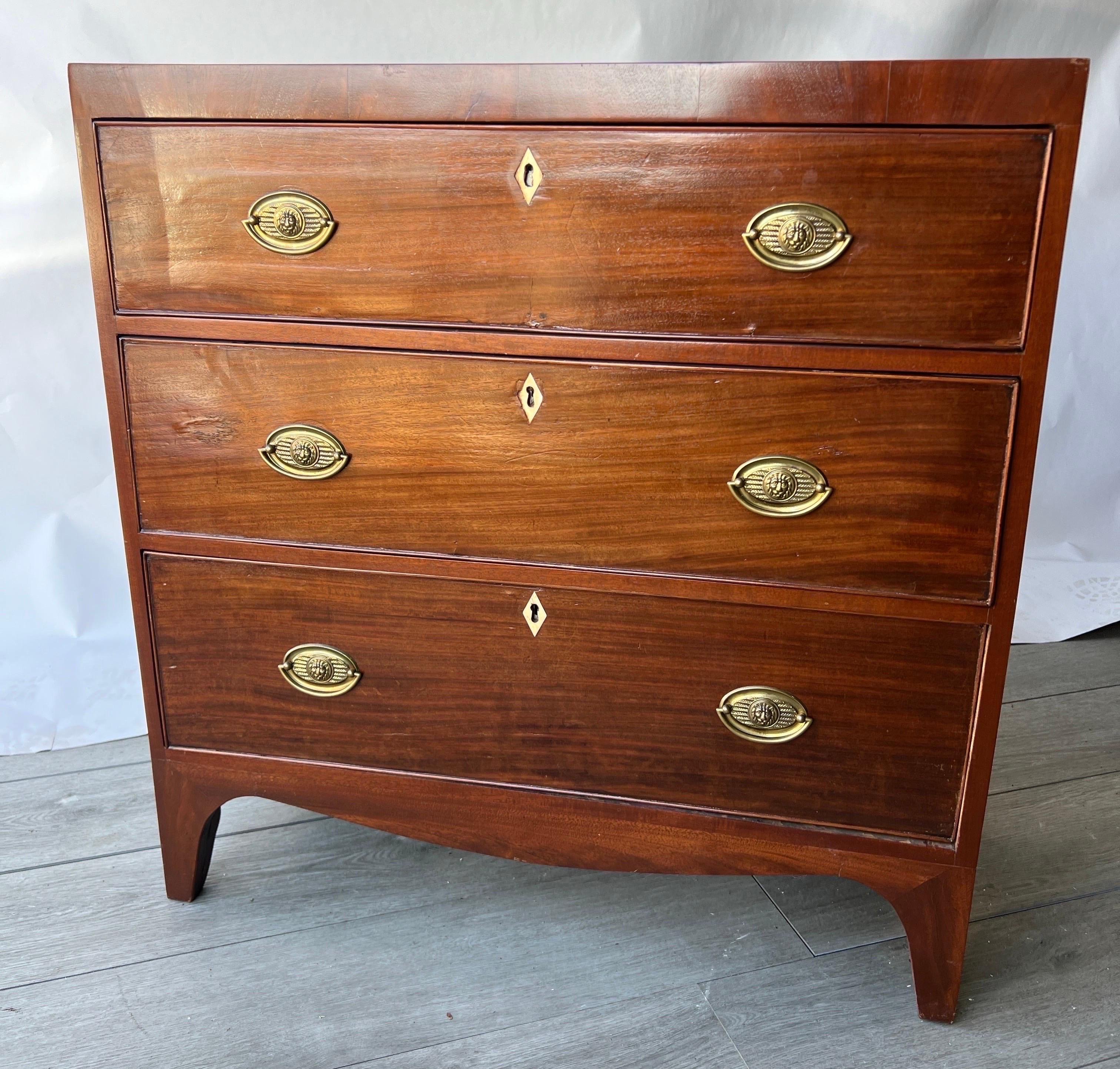Great little 19th century English regency period bedside chest. Decorated with lion head pulls and featuring inlaid bone escutcheons. The depth is less than 14” , which makes this a very desirable chest for small nooks and bedrooms. 