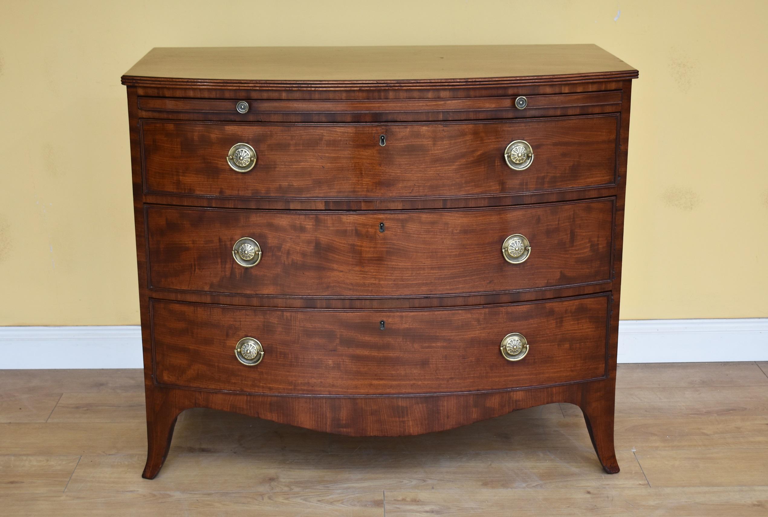 For sale is a top quality Regency mahogany bow front chest of drawers, the top being veneered in superb figured mahogany, with brushing slide below, having two brass handles. This is above three drawers, each with fine brass handles. The chest is