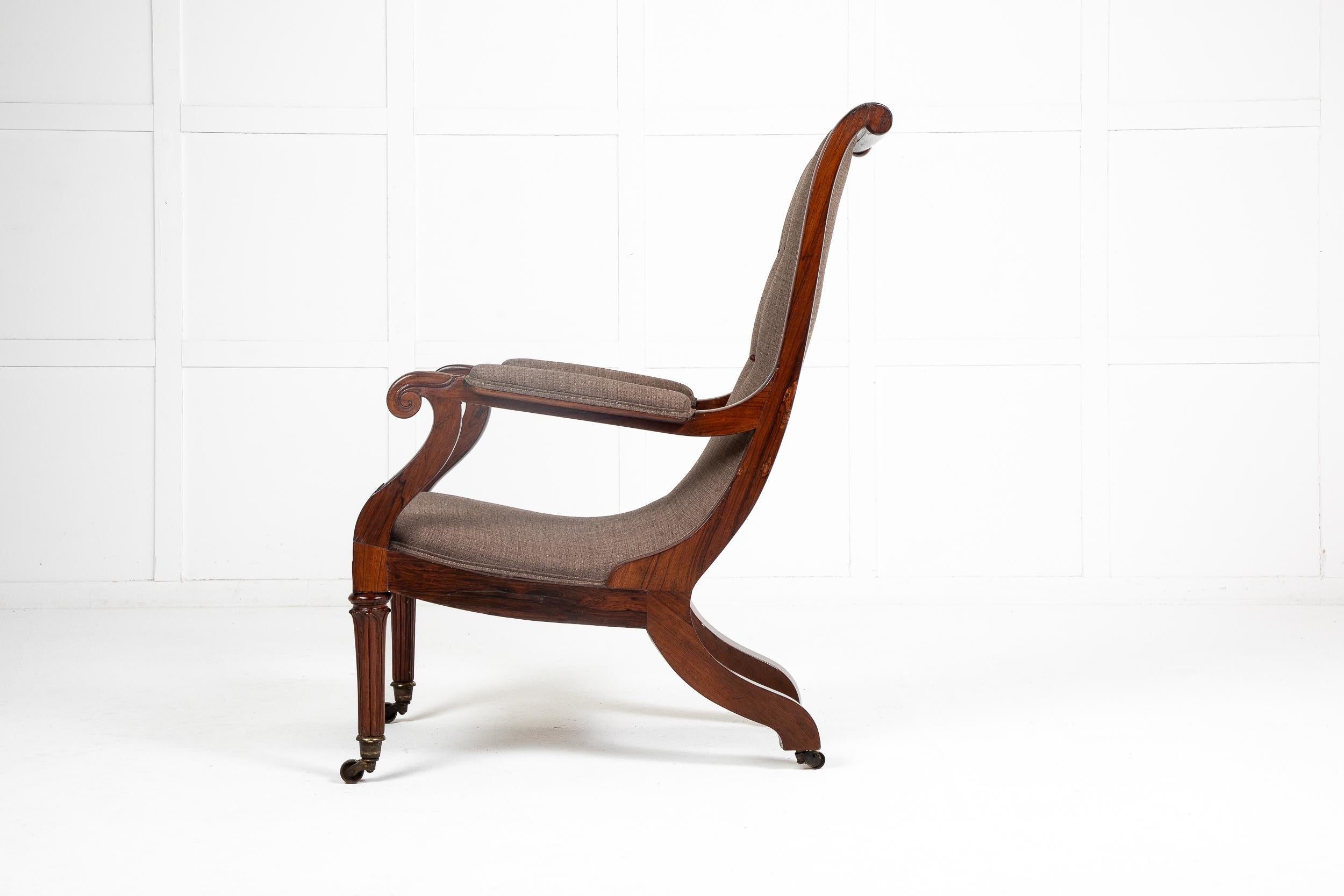 19th Century English Regency rosewood armchair. The whole of the scroll top back and the seat join together in a sweeping curve to give it its elegant shape. Having scrolled arm ends and padded armrests. Raised on outswept back legs and long, turned