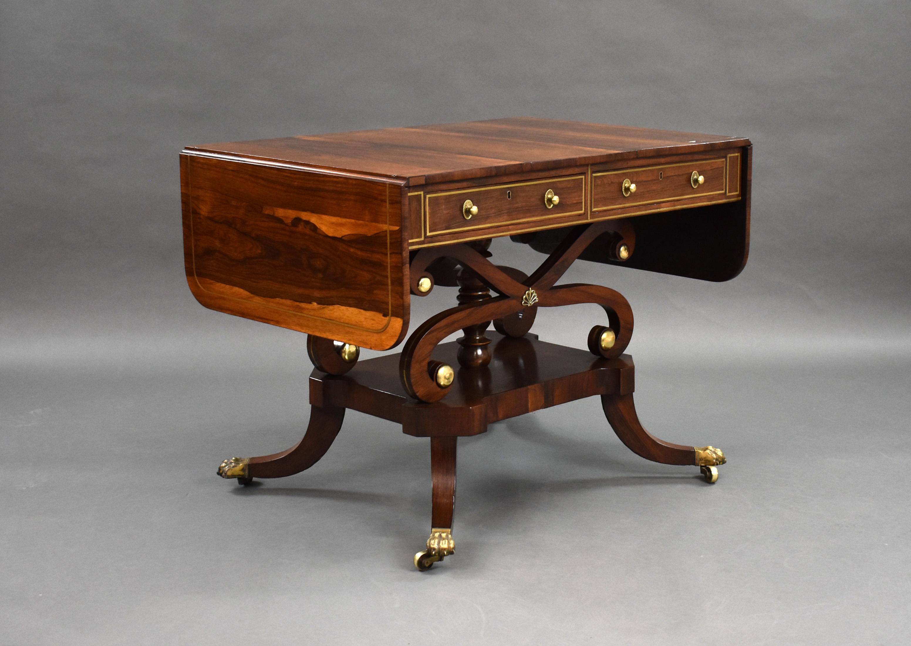 For sale is a fine quality Regency rosewood brass inlaid sofa table, the well figured top having two drop leaves, inlaid with brass line above two drawers to the front, with two faux drawers on the opposing side, each inlaid with brass line, above