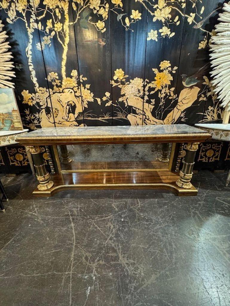 Questa consolle in stile Regency inglese del XIX secolo presenta un lussuoso piano in marmo ed è realizzata in squisito legno di palissandro. Il tavolo vanta intricati intagli in legno dorato che ne esaltano l'eleganza e la raffinatezza. Questo