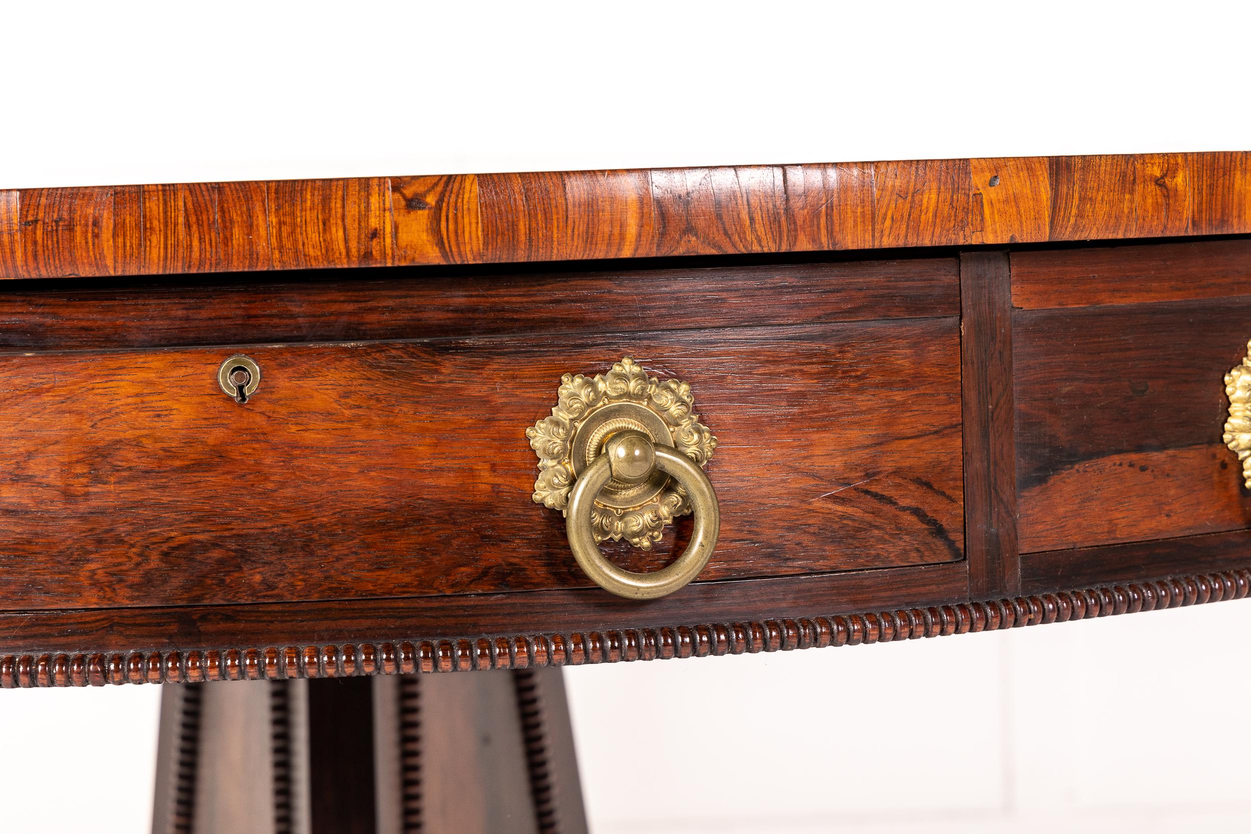 A super quality, 19th century English rosewood drum table with mahogany draw linings and original handles. Beautiful use of rosewood veneer to the top and edges. Having four frieze drawers and four false drawers with very large brass handles.