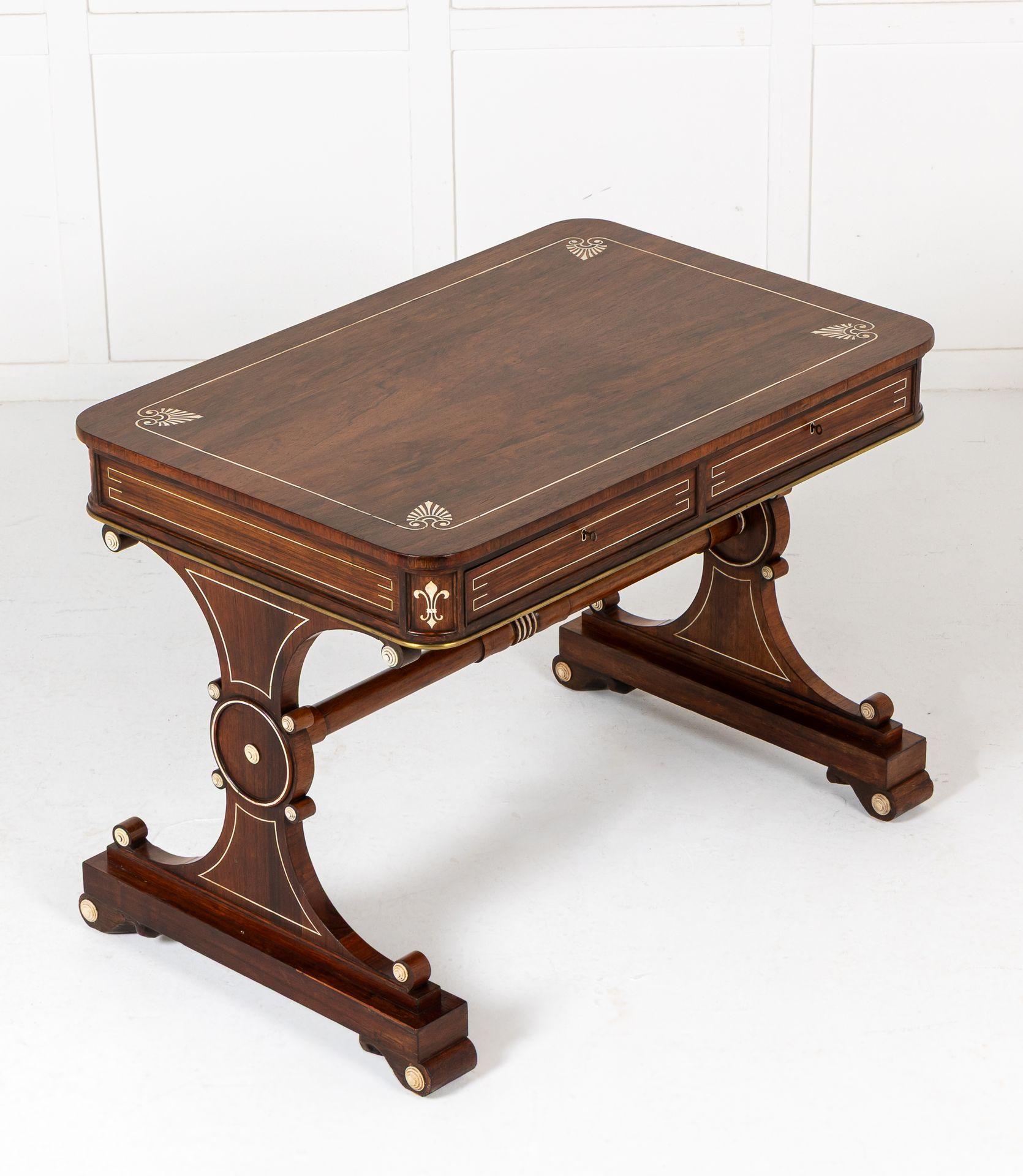 19th Century Regency rosewood library table with ivory inlay. 

This beautiful table would have been the height of luxury in the Regency period when it was made. Supported on two end supports of hourglass shape, there are turned ivory paterae and