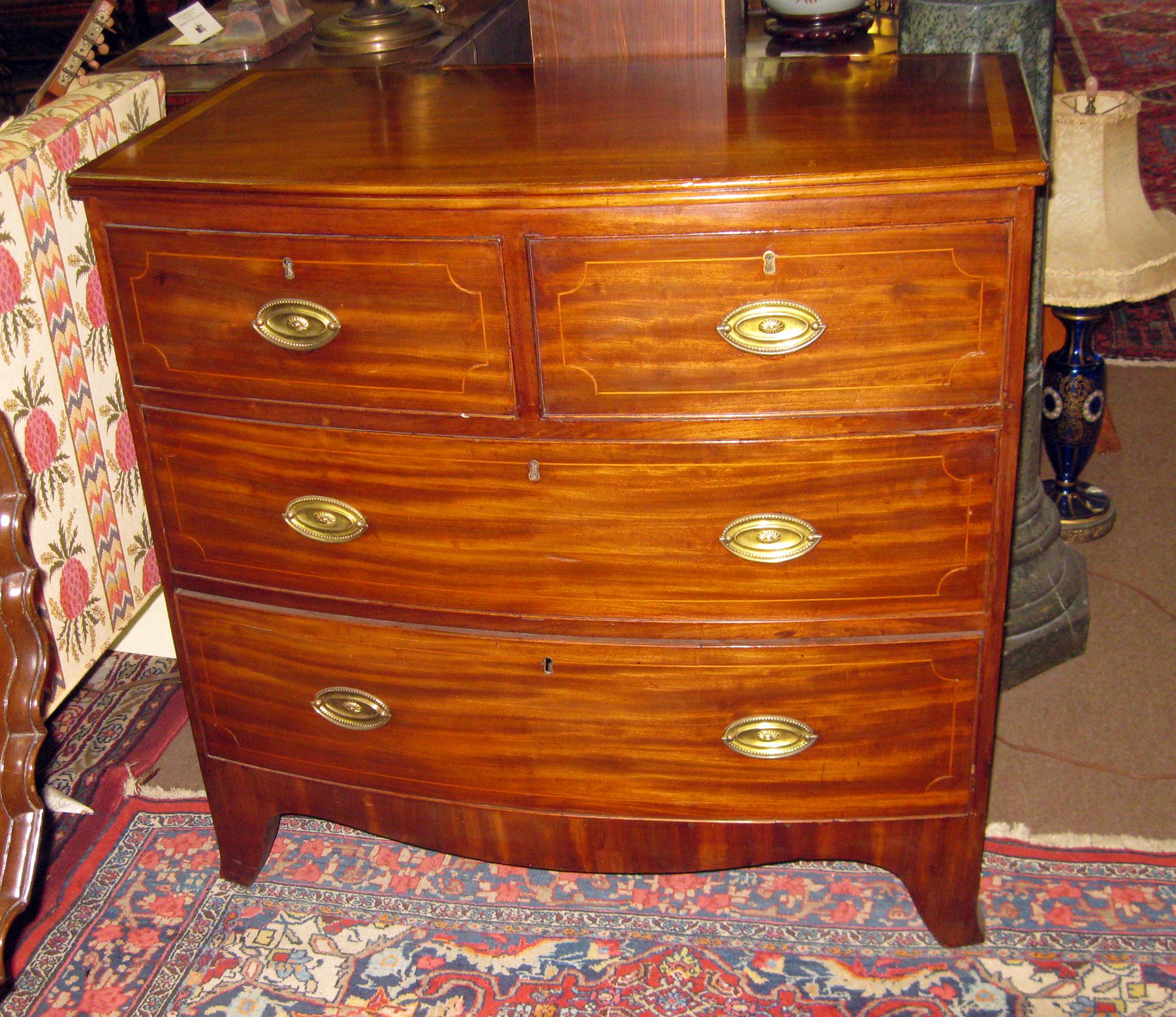 Classic Regency style English bowfront mahogany chest featuring four drawers, subtle inlay and brass pulls. The slightly bowed top measures 19.50 inches deep at the center 