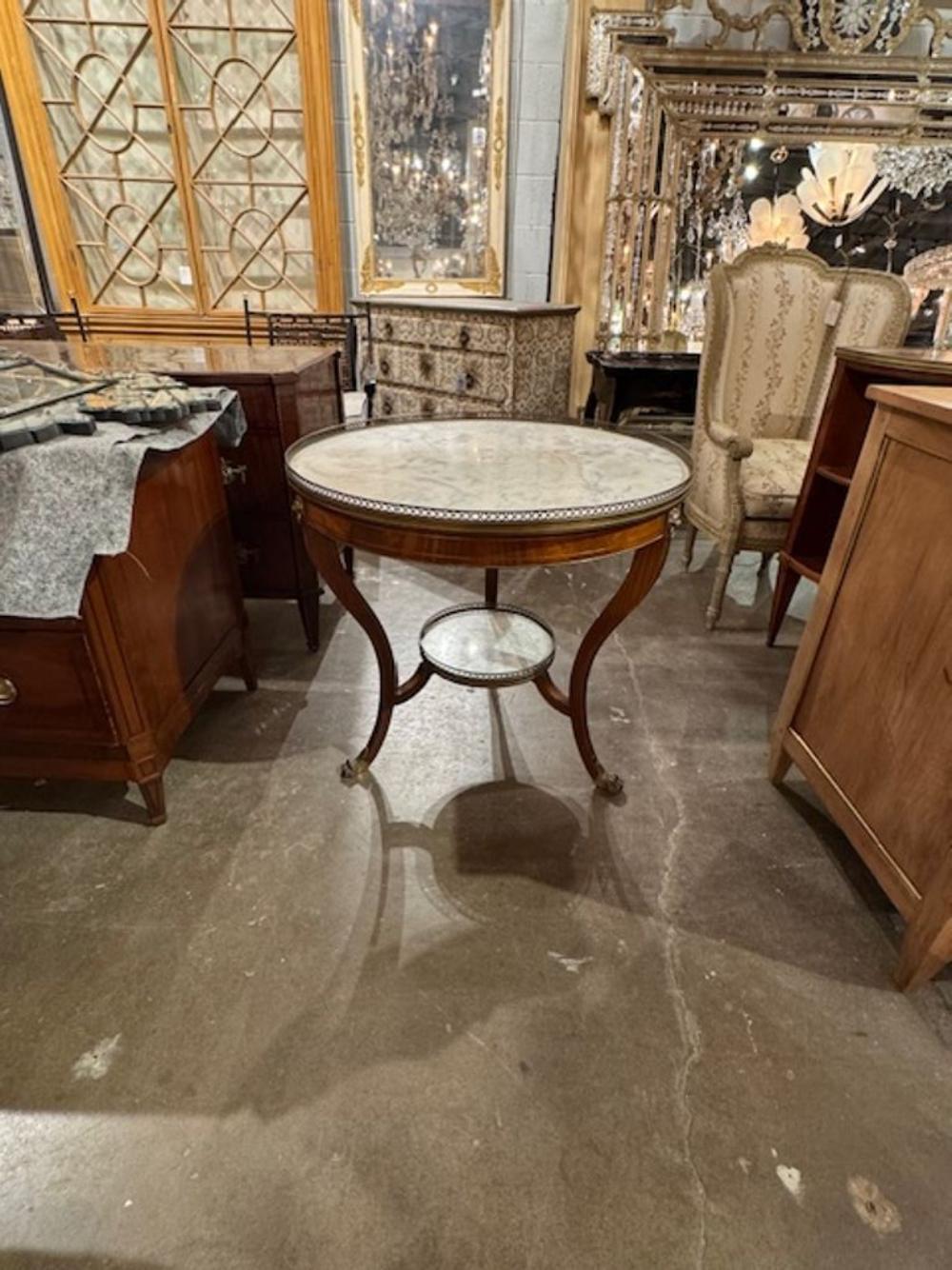Experience the elegance of the 19th century with this exquisite English Regency style Gueridon table. Crafted with a stunning walnut base and a Carrara marble top, this piece is a testament to timeless design and craftsmanship. The brass finish adds