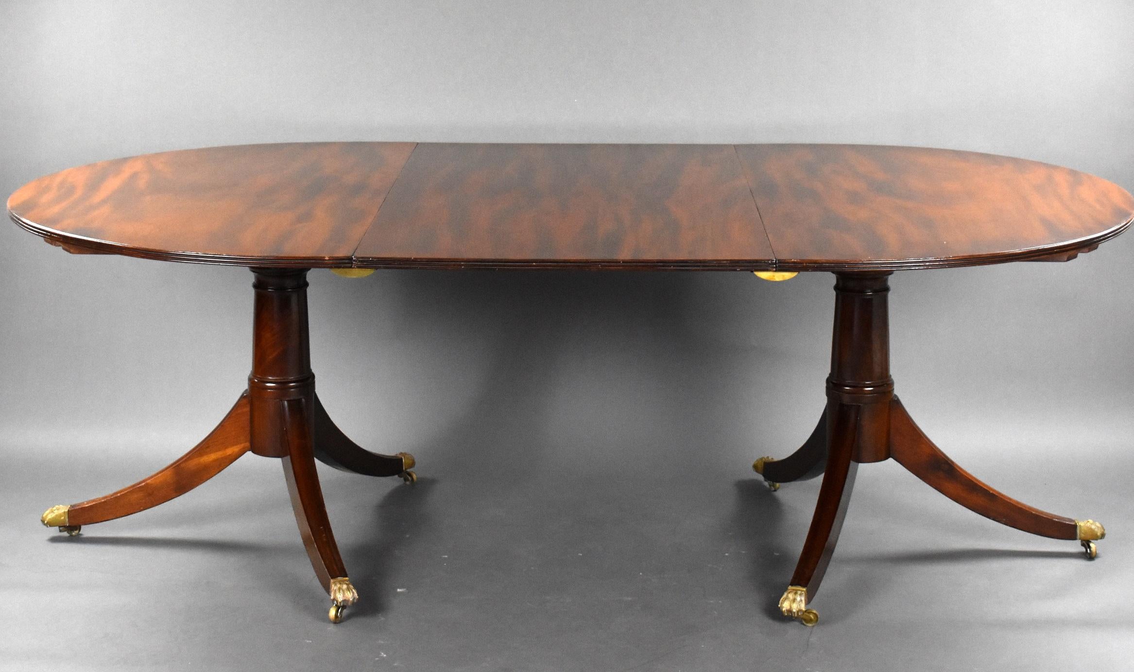 For sale is a good quality 19th century mahogany pedestal dining table, having a well figured top with an additional leaf, the table is on gun barrel supports, having elegantly splayed legs raised on brass lions paw castors. The table is in good