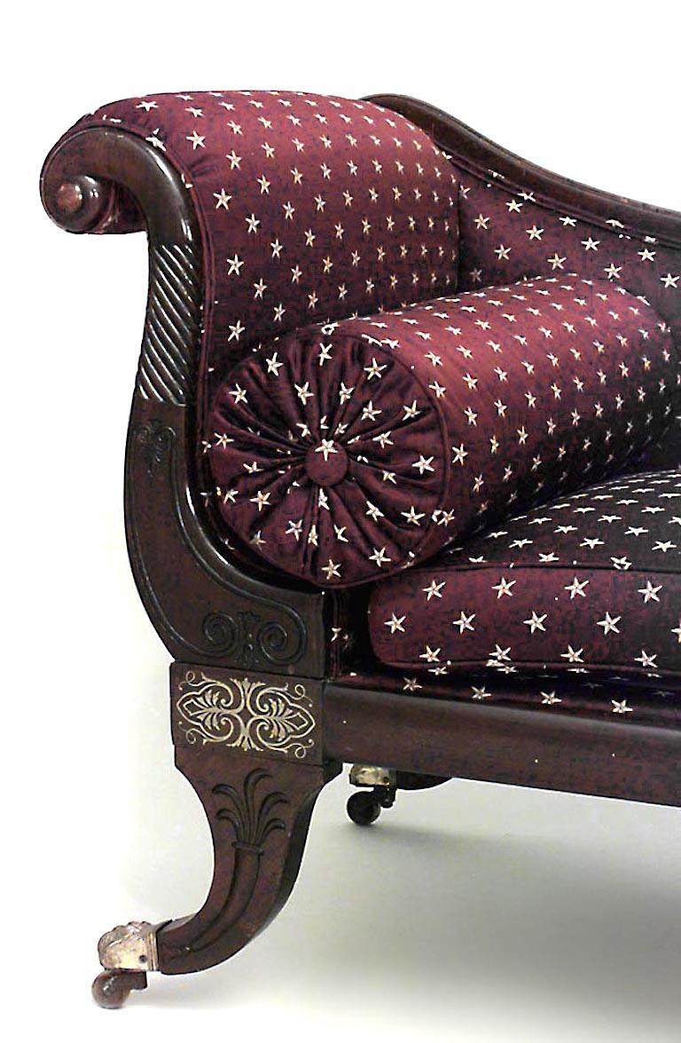 English Regency-style (19th Century) mahogany and brass inlaid roll arm r√©camier with maroon and gold star design upholstery.
