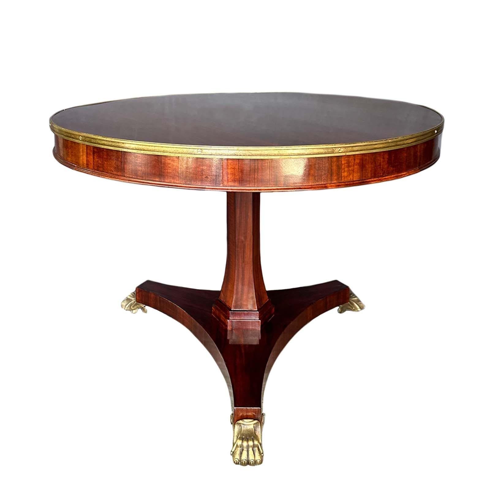 Amazing 19th Century English Regency tilt-top center table crafted from rosewood. The table's opulence is accentuated by its meticulous bronze mounts, adding a touch of timeless elegance to any space. Supported by sturdy bronze lion paws, this table