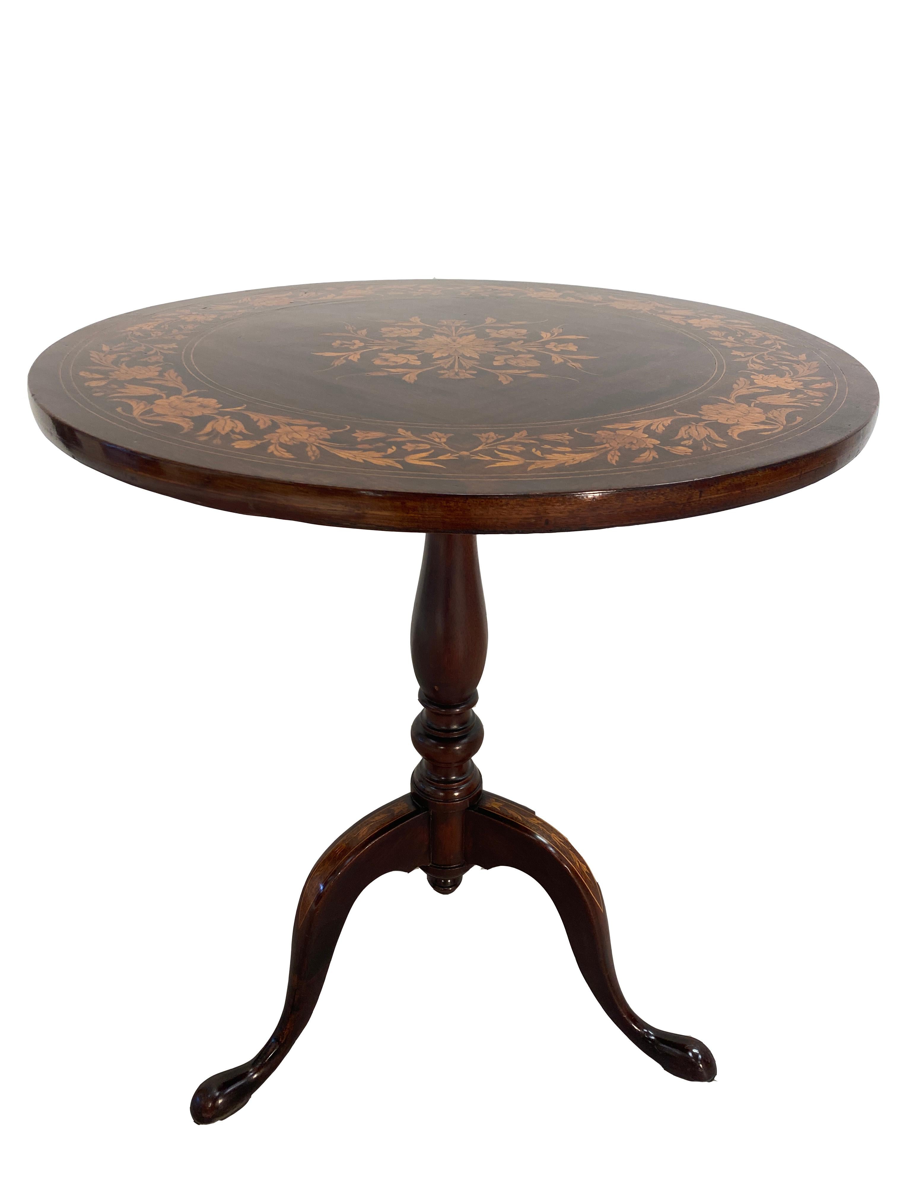 This is a very good condition Mahogany English Regency tilt top teat table with Marquetry inlay. The round table is attached to a three legged stand. The top and legs are adorned with Marquetry inlay. The finish is highly polished. The top is stable