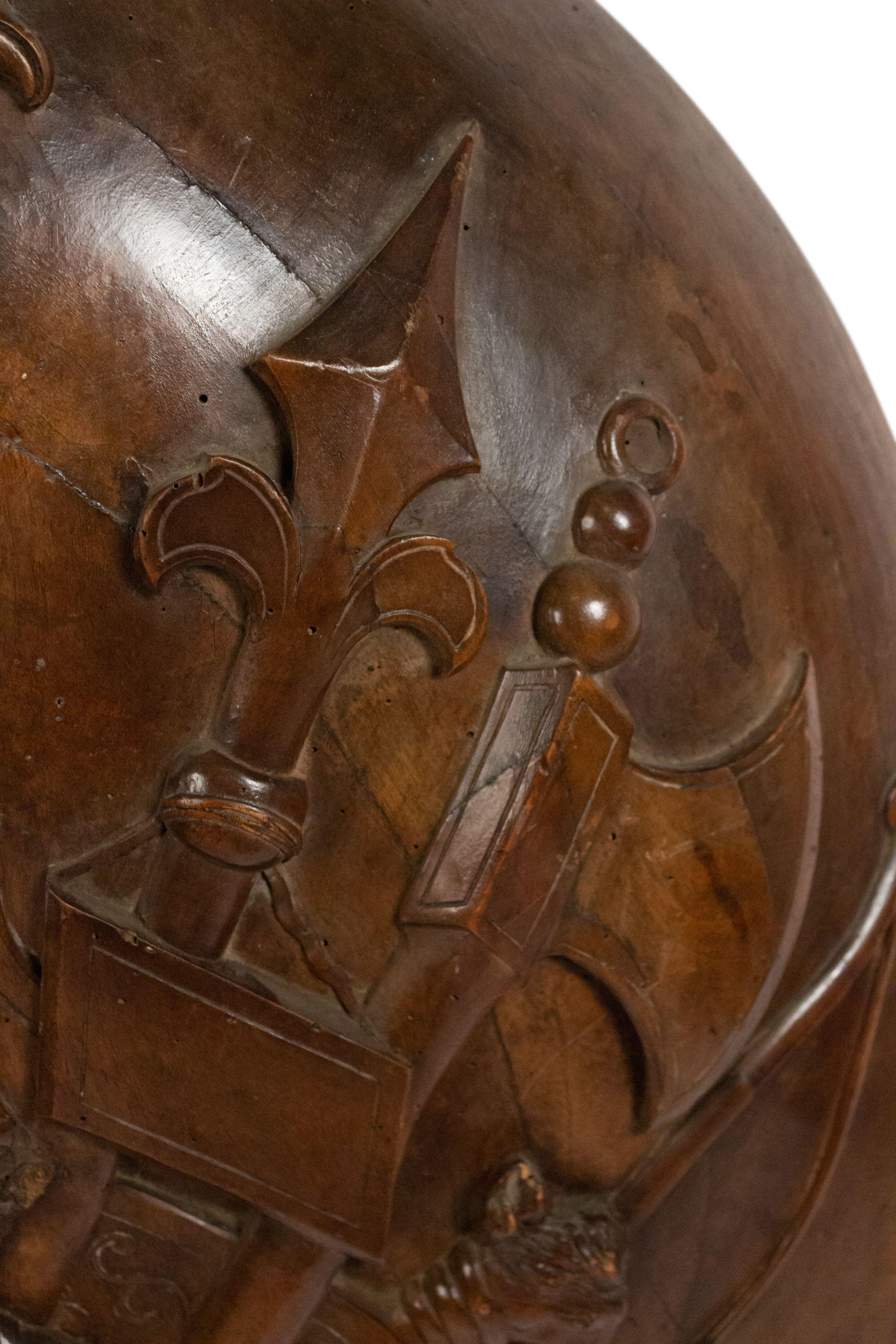English Renaissance style (18/19th Century) round shaped walnut wall plaque with military motif of spears and armor in relief.
