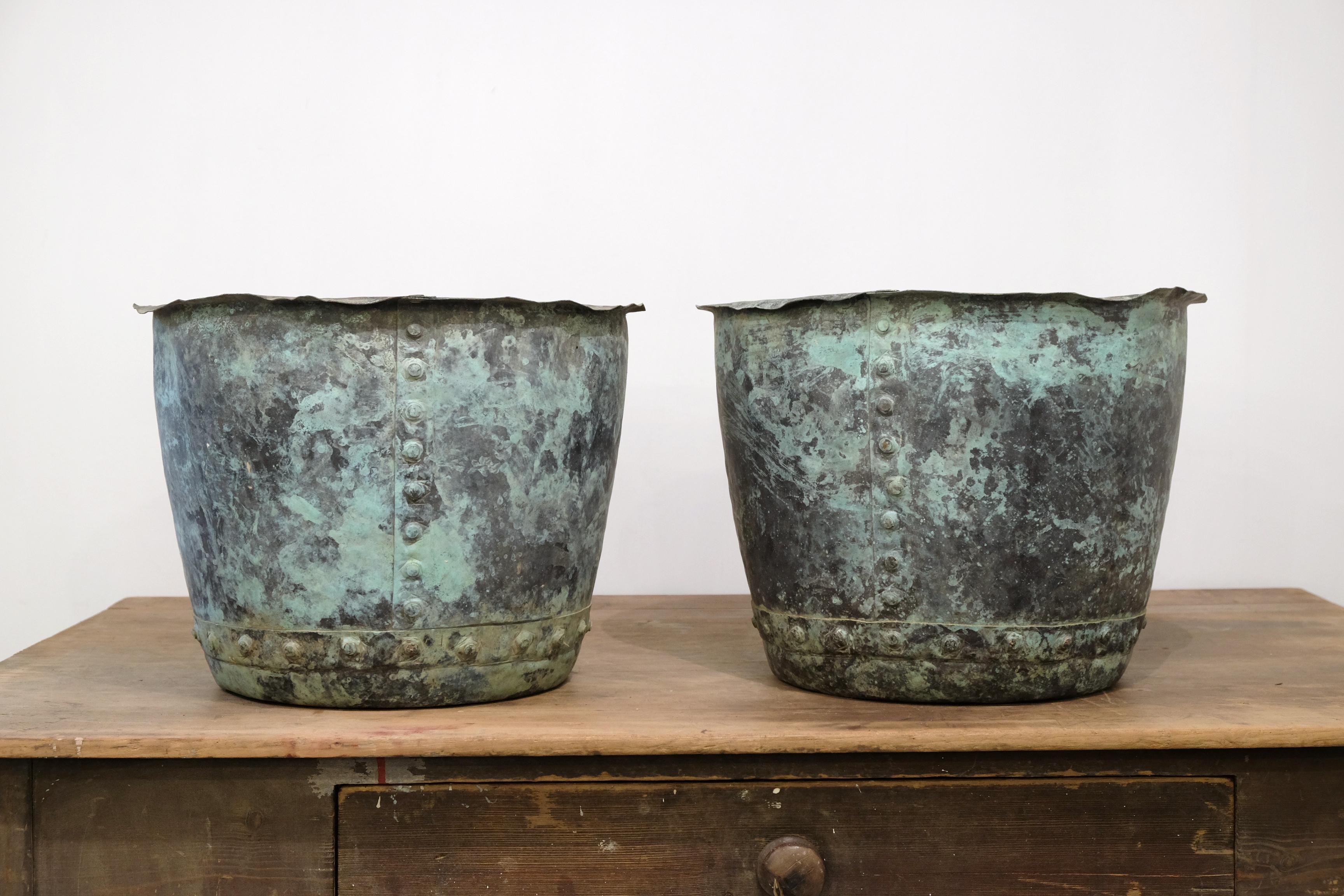 Riveted copper ‘coppers’ with fantastic natural verdigris patina. They are both unique but make a great pair. Have been drilled on the bottom for drainage so perfect as planters but they would also make superb log baskets, English, circa