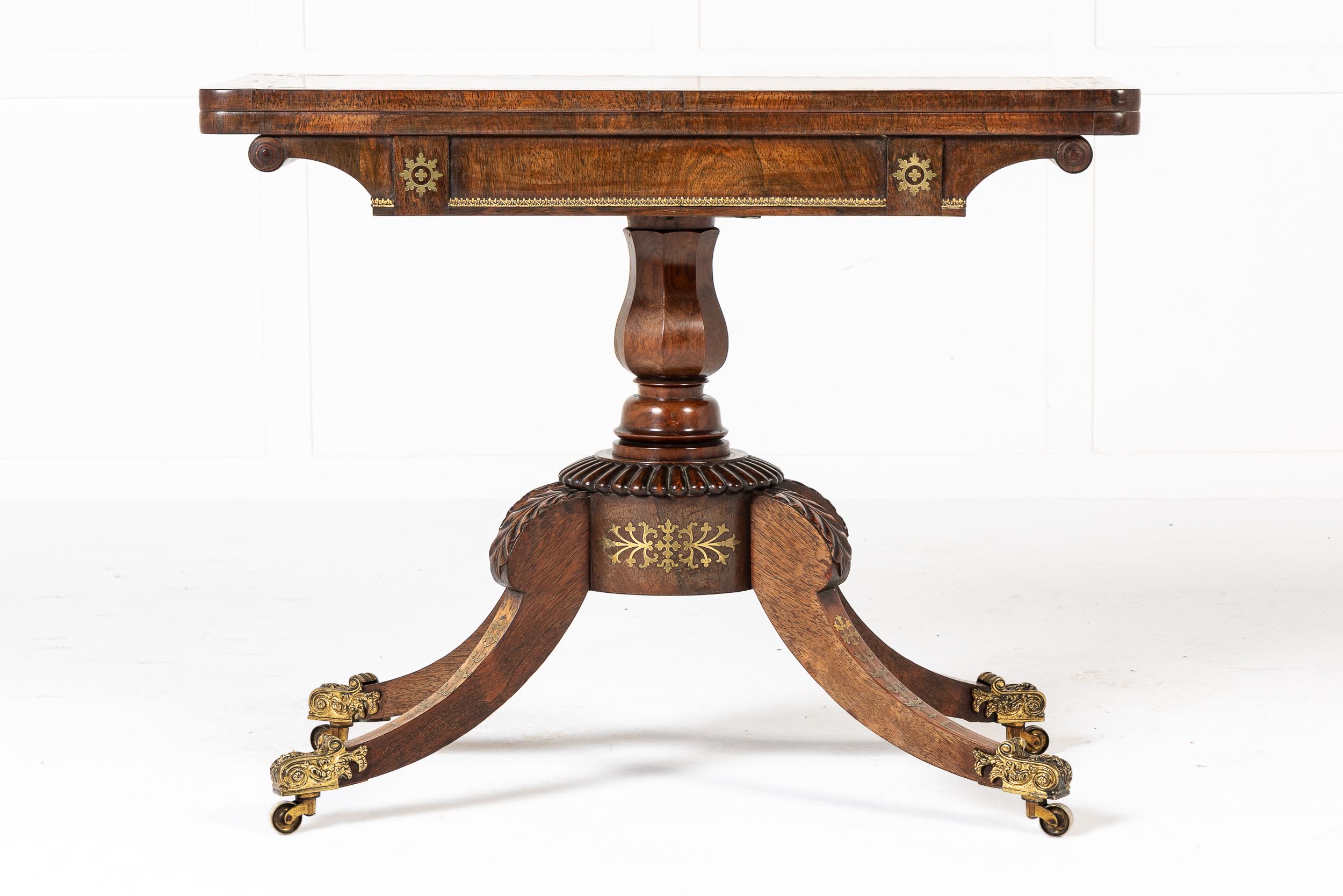 Excellente table à cartes en bois de rose incrusté de laiton du XIXe siècle.

Plaquée de bois de rose d'une qualité et d'un aspect excellents, cette pièce comporte quatre pieds en sabre qui rejoignent une colonne centrale en forme de vase dont la