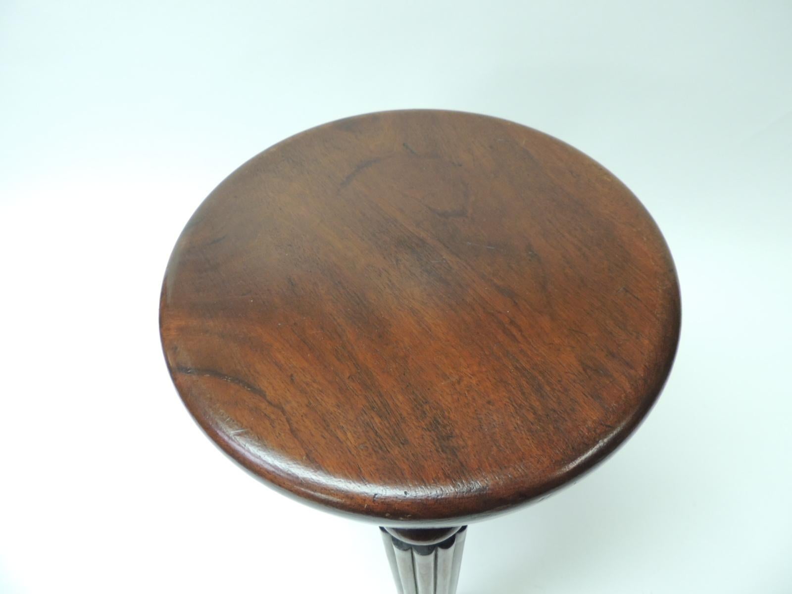19th century English round footstool
Tripod style fluted legs milking stool with thick round seat
Mahogany finish on wood,
circa 1830
Size: 10 D x 13.5 SH.
 