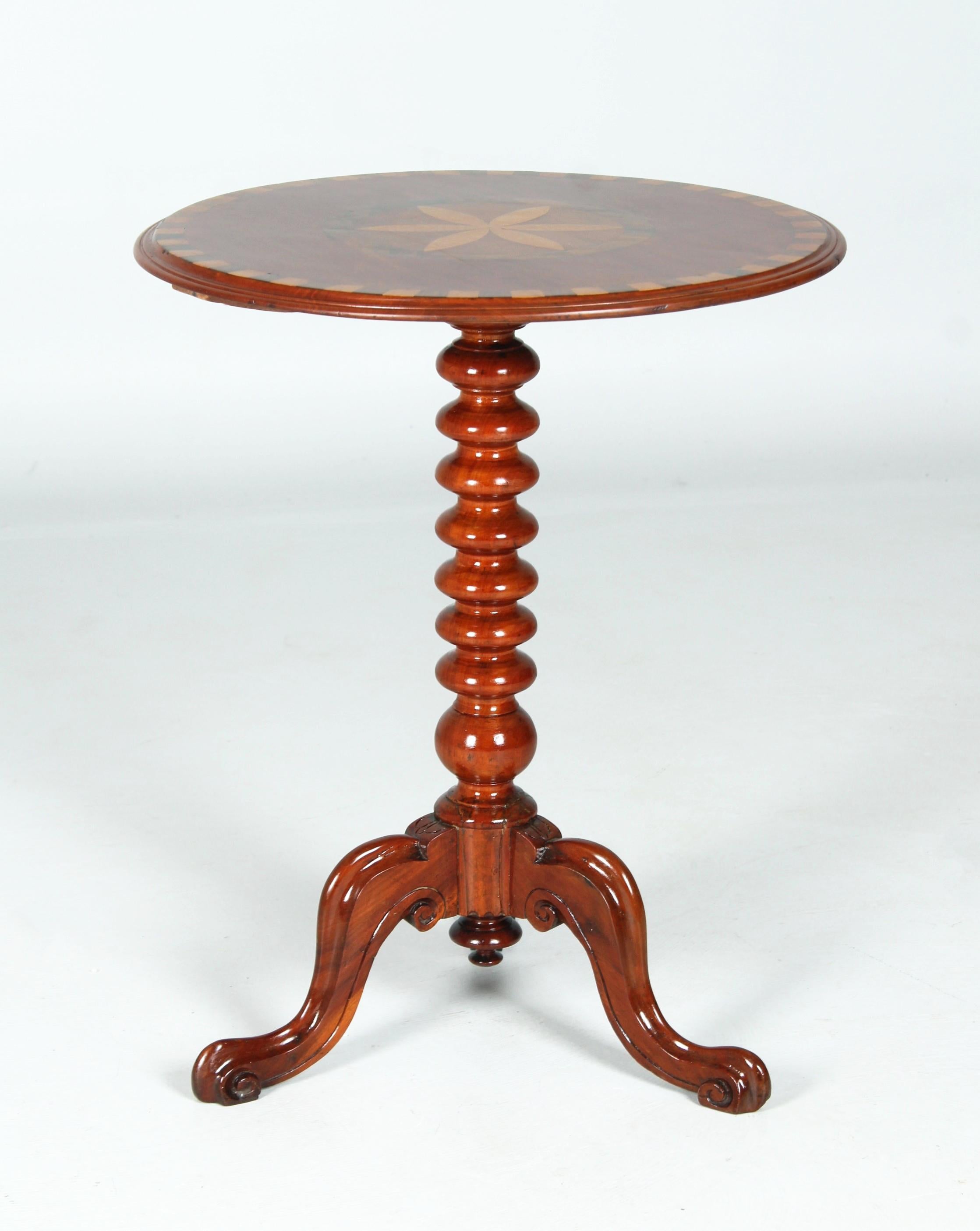 Antique side table with star inlay

England
Mahogany and others
second half of the 19th century.

Dimensions: H x D: 71 x 57 cm

Description:
Small table standing on a three-legged, carved base with a turned centre column and inlaid top.
The inlays