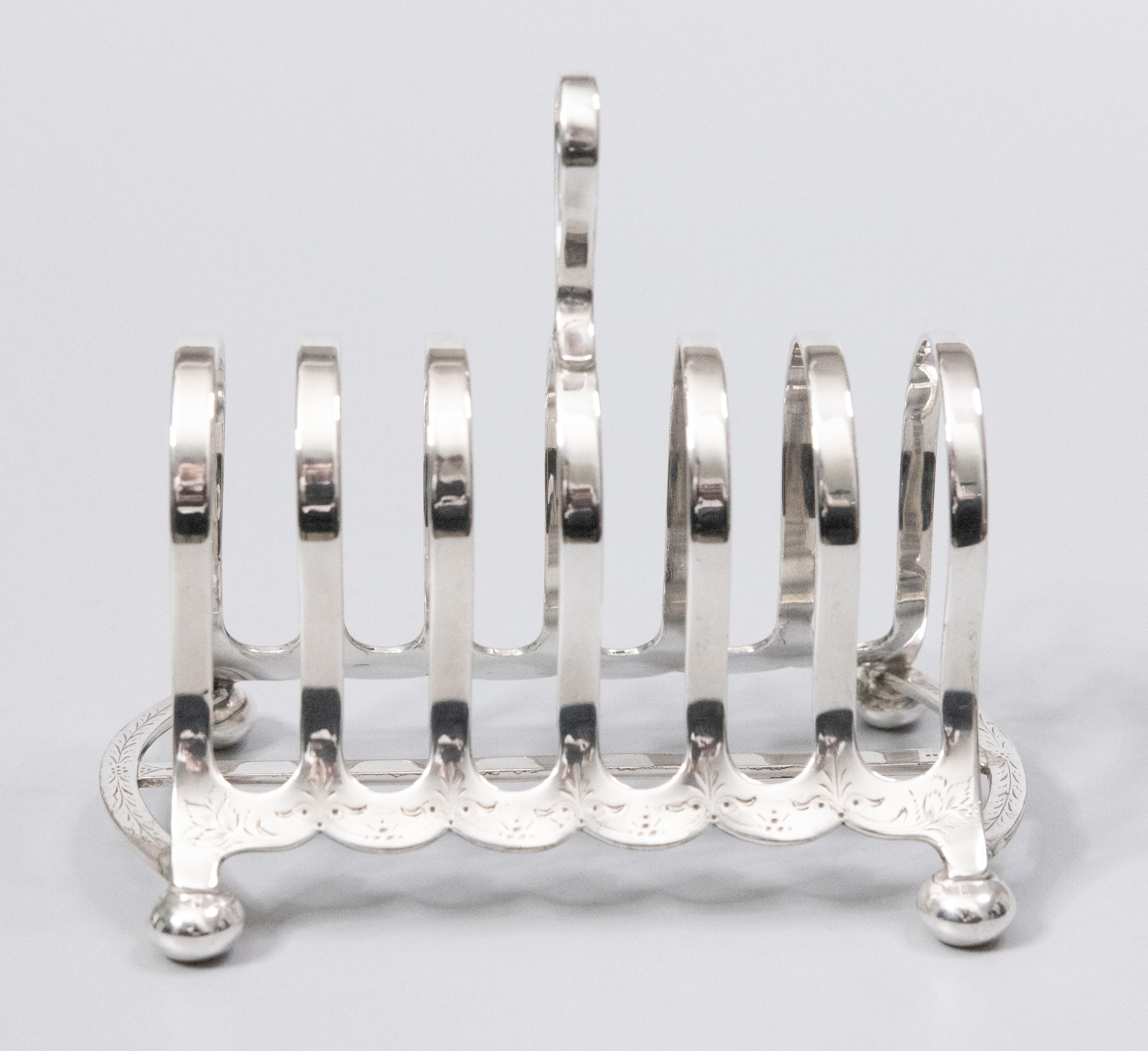 A superb large antique English Victorian silverplated six slice toast rack. Maker's mark on reverse. This fine quality silver toast rack is well made with a lovely arched shape, delicate etched details, and charming bun feet. It would be wonderful