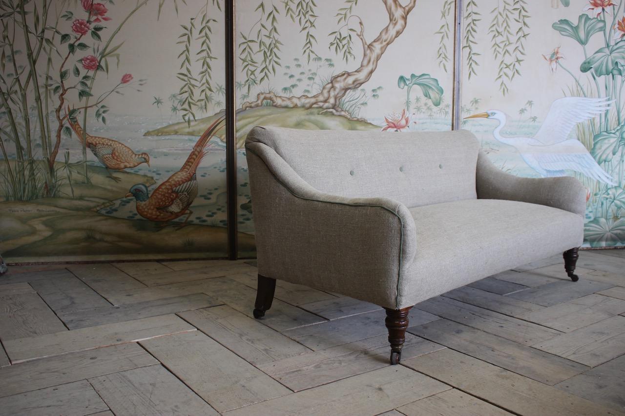 A 19th century English sofa of small proportions, having been reupholstered by us in a neutral linen with contrast piping, ideal for small rooms or at the bottom of the bed. 
Measurements: 40cm high (floor to seat)
England.