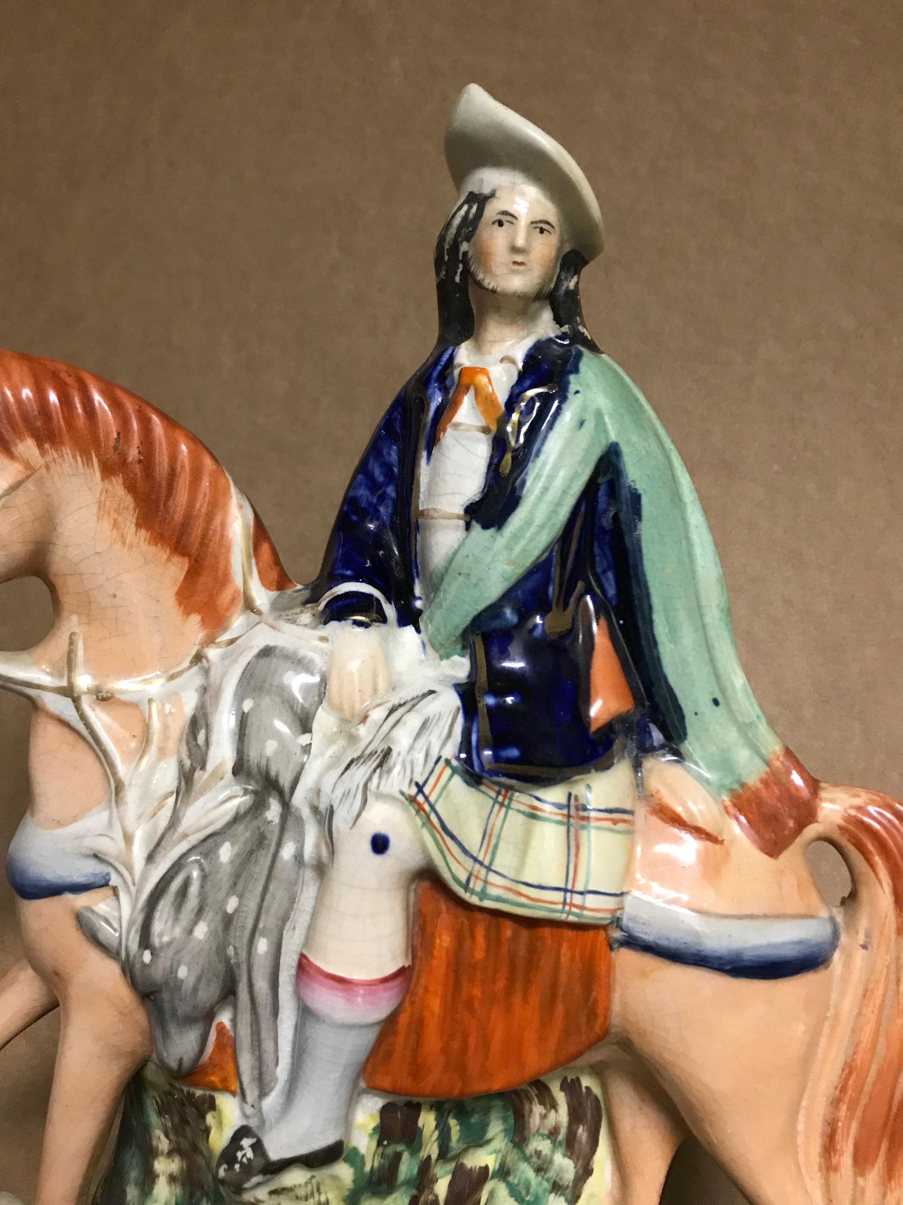Beautifully painted and impressive scale Staffordshire group of a hunter dressed in Scottish plaid kilt riding back from the hunt with his quarry, a stag draped over the horse. I love the naive depiction of real life, and the charming face horse has