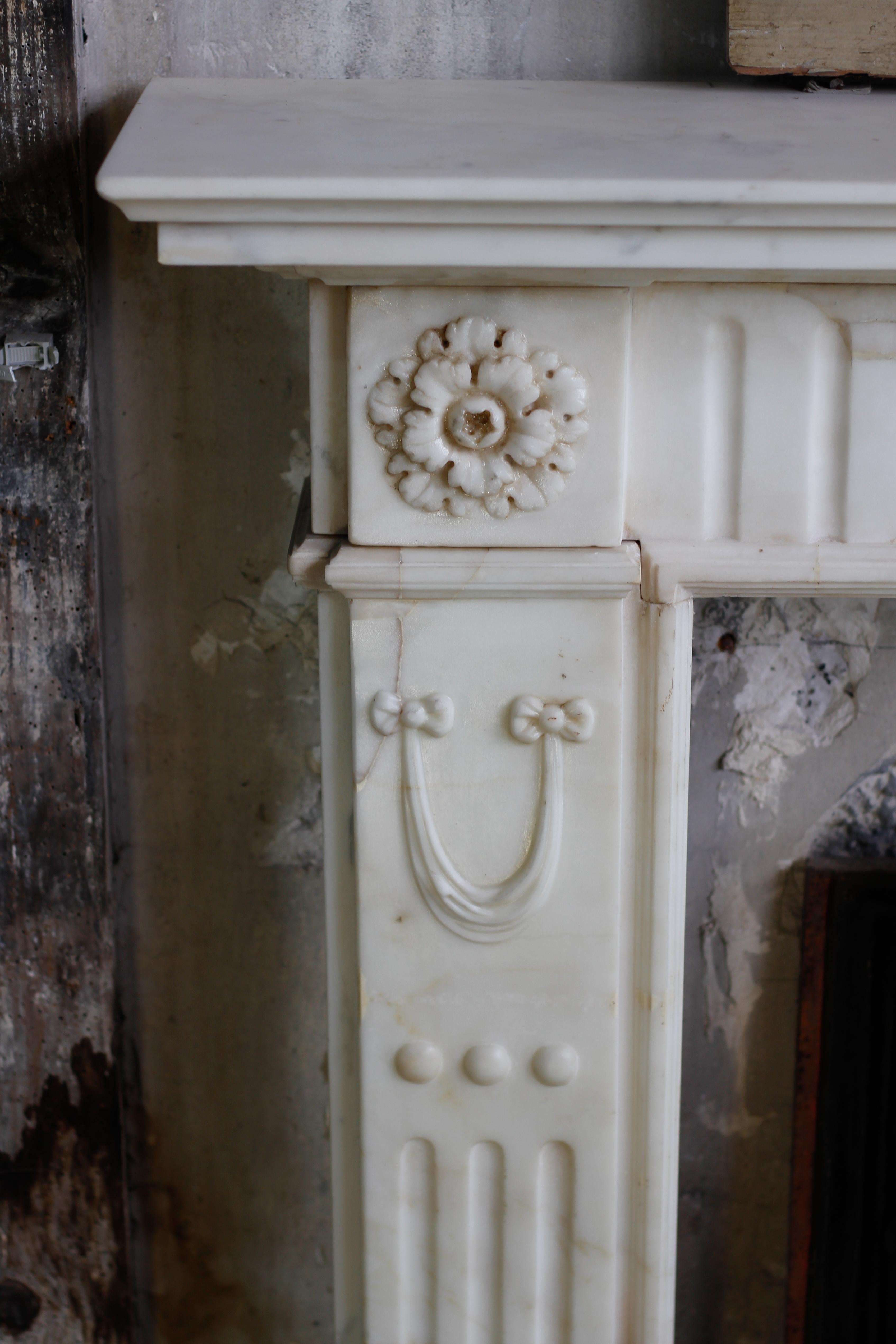 19th century English statuary marble fireplace mantel

This rare mantel was made during the 19th century and made out of a very white marble. The entablature is carved with fluting all along its length and two round rosettes decorate the