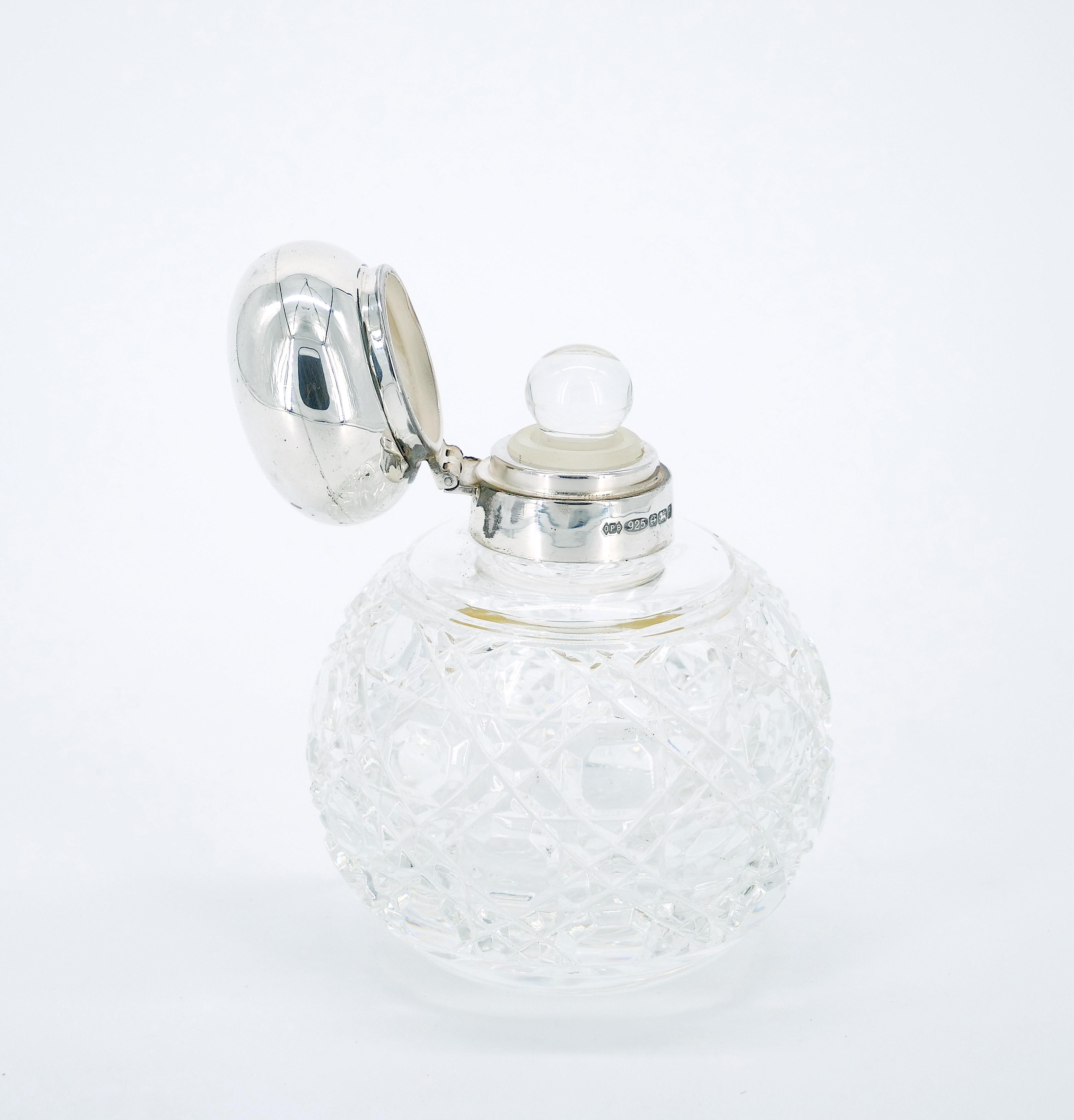 Transport yourself to the elegance of the 19th Century with this exquisite English Sterling Silver Covered Top and brilliant Cut Glass Perfume Bottle. The perfume bottle showcases a hobnail sterling silver top complemented by an engraved brilliant