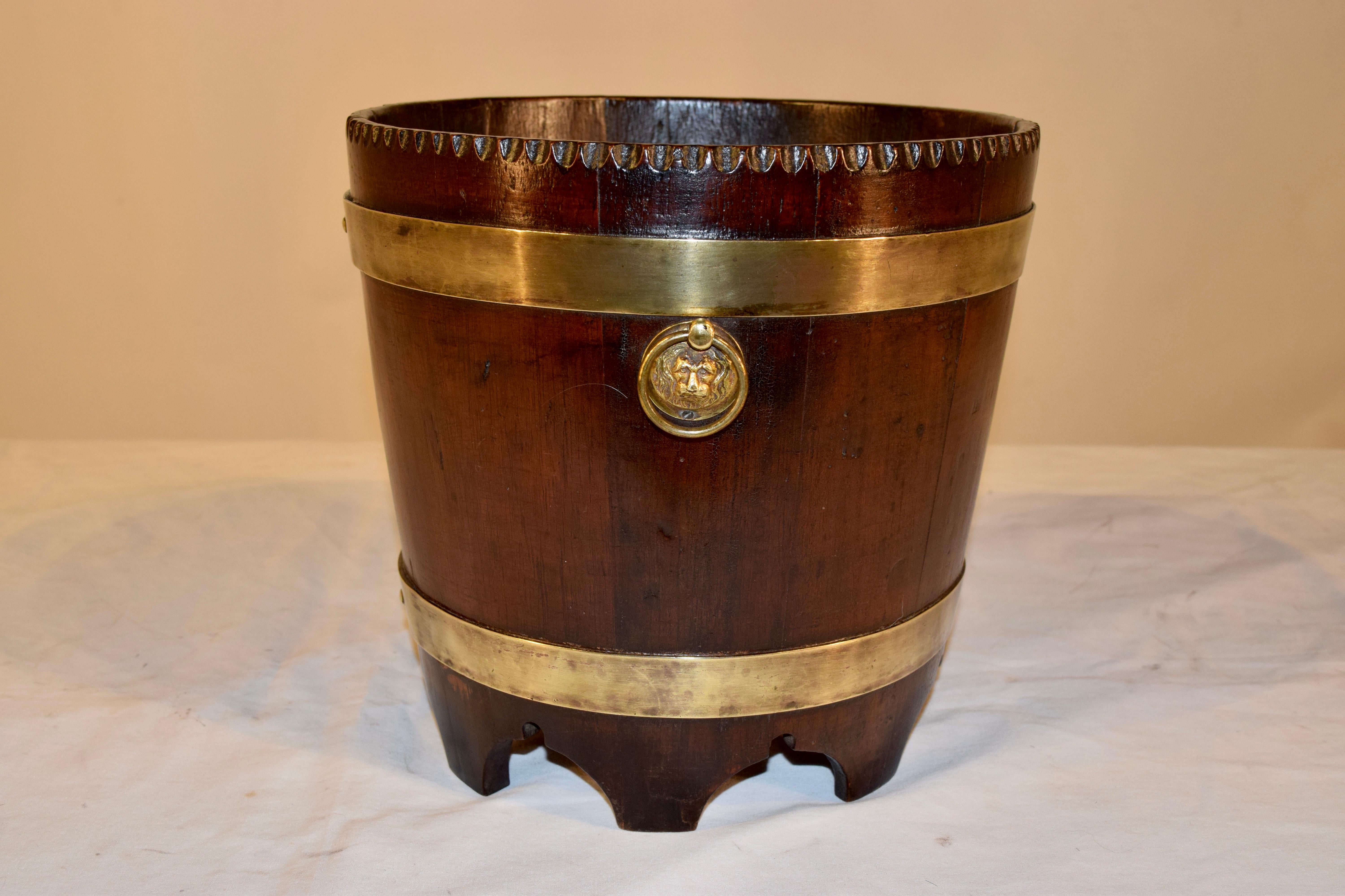 19th century English oak bucket strapped in brass banding. Lovely pie crust edge detail at the top and scalloped feet on the base.