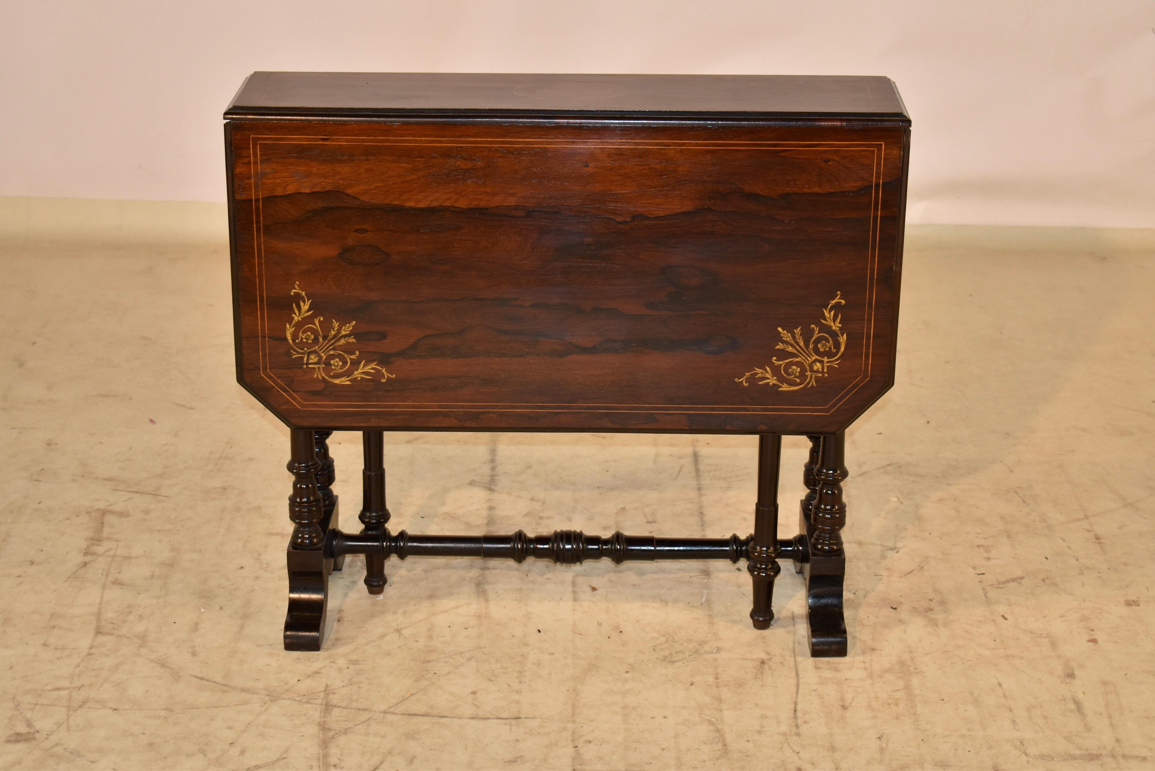19th century Sutherland table from England made form Rosewood. The top is fantastic and has lovely graining, inlaid with satinwood and boxwood banding and decorative accents in the corners. The top with the leaves extended measure 35.75 w x 30 d.