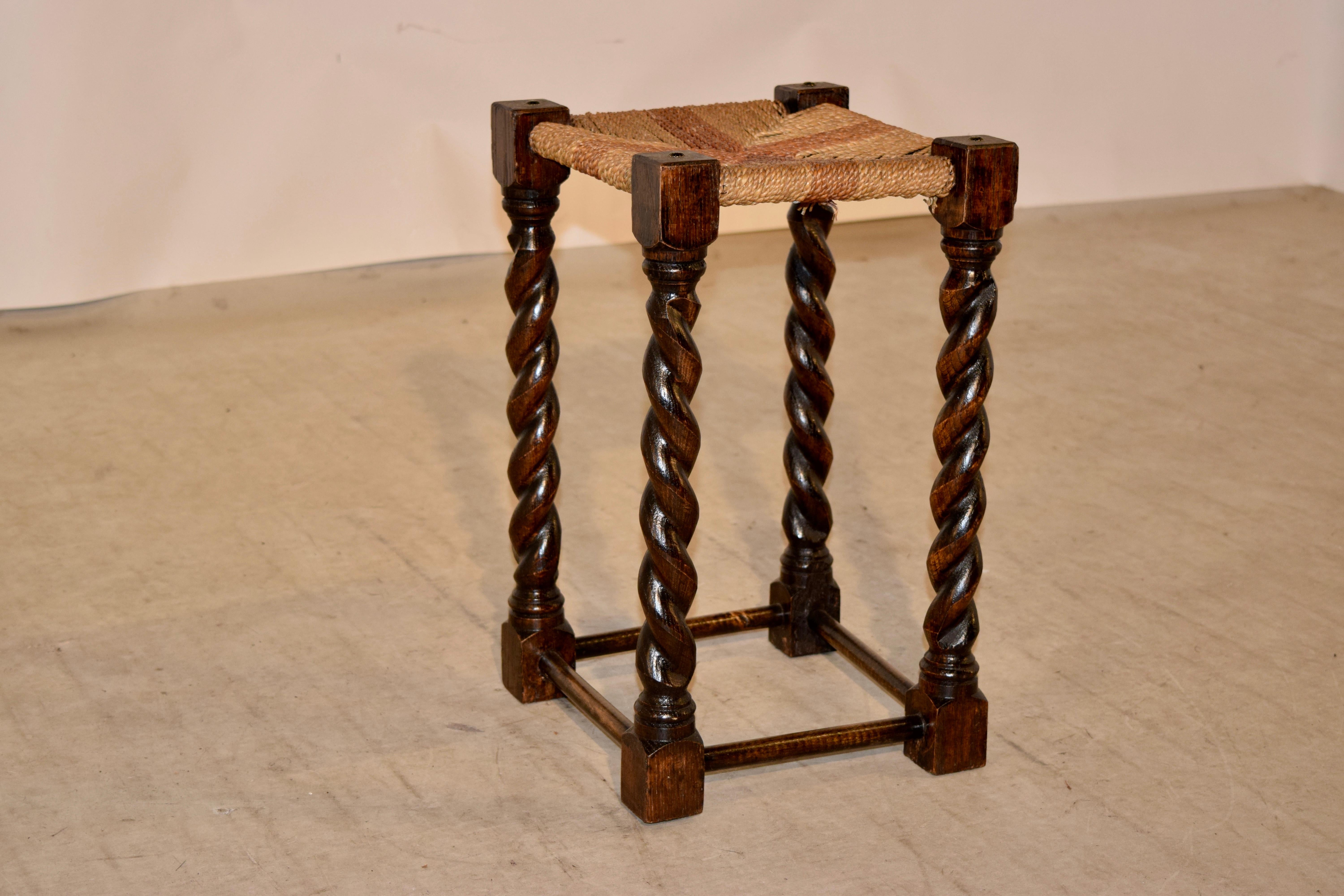 19th century oak stool from England with a hand woven rush top and hand turned barley twist legs joined by simple stretchers. Great height.