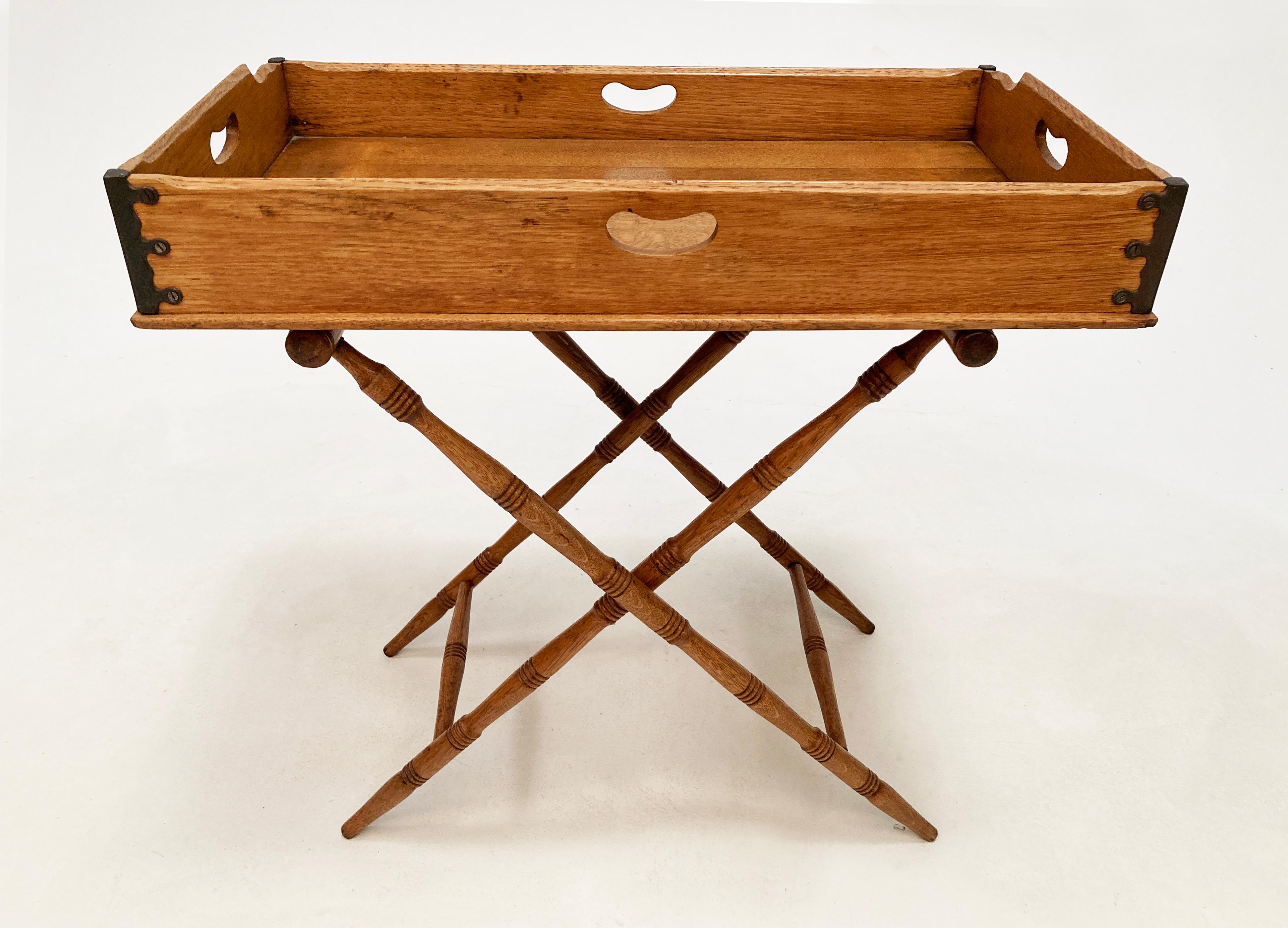 This rare tiger oak Butler's Tray with folding base, leather stand-straps and iron corners is a stunning example of smart functionality and beautiful design. This sturdy and uniquely figured oak tray is removable and features keyhole handles on all