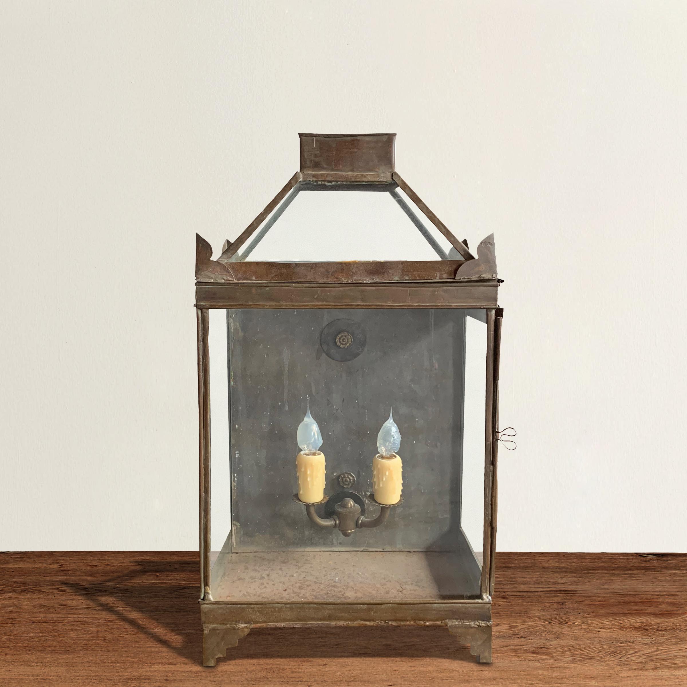 A charming 19th century English wall mount tole lantern with glass sides, a removable glass roof, and a door on one side. The lantern has been recently electrified with two candles and can be hardwired or used with a plug.