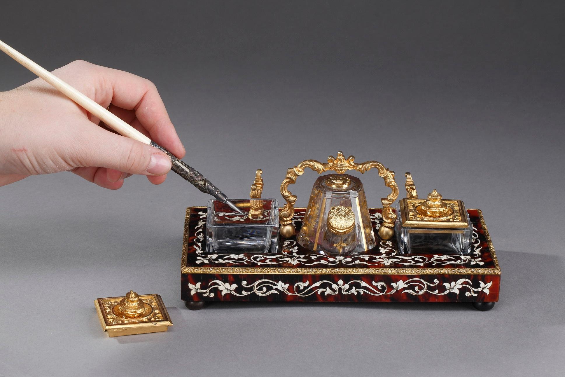Small English ink stand crafted of tortoise, crystal and gilt bronze by Patent in London. It is richly decorated with inlaid foliage and floral motifs. This stand is well appointed for the writing with its three removable, cut-crystal vessels with