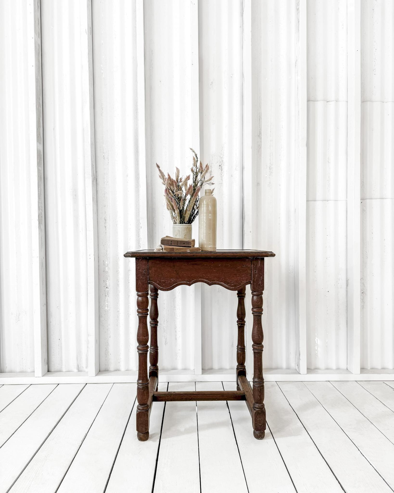 Charming side table having a scalloped apron and turned legs. The top features an inlaid design, finished in a molded beveled edge and softly clipped corners. Molded edge supports join the legs, which rest upon bun feet. A versatile and stylish