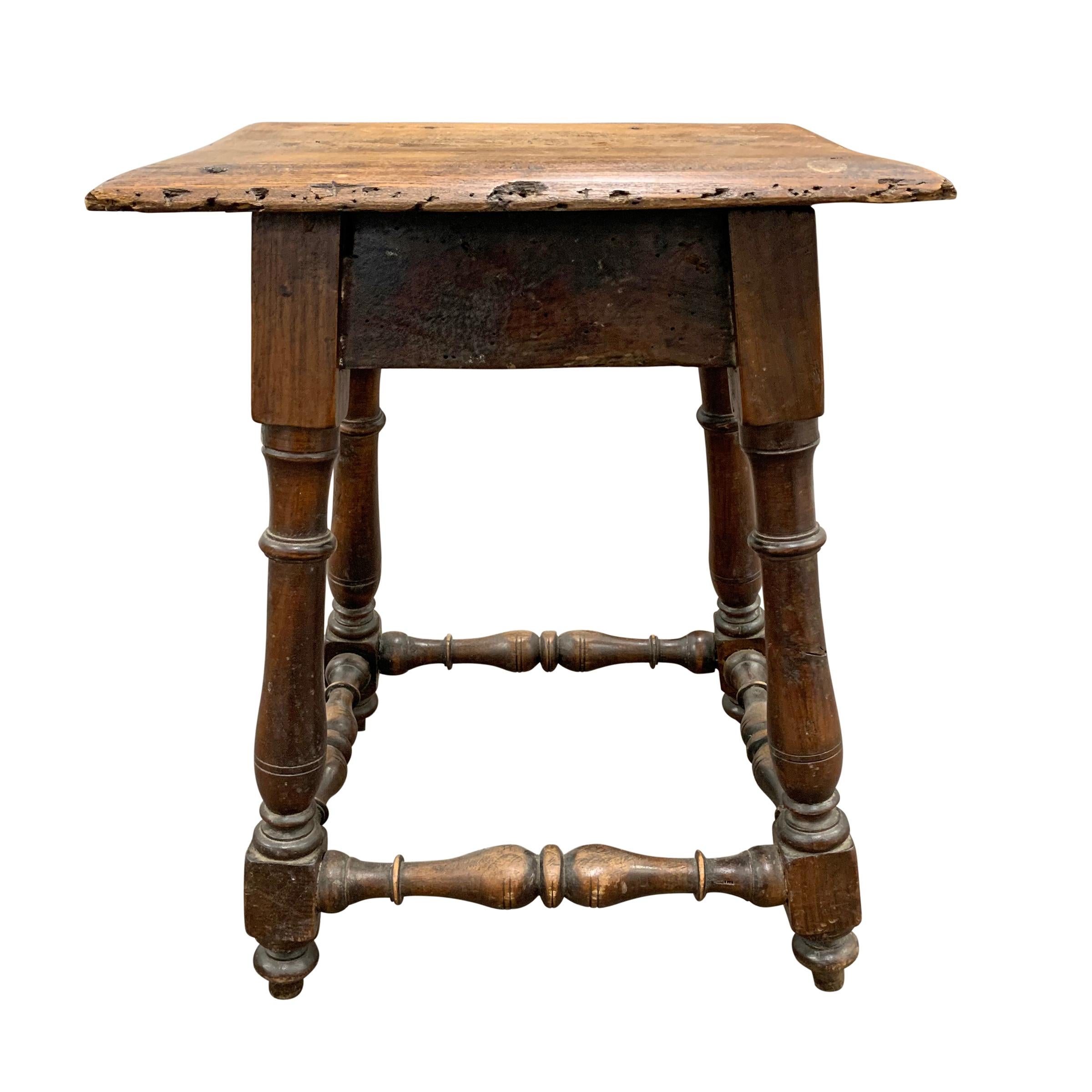 A beautiful early 19th century English pub stool with elaborately turned legs and stretchers showing two centuries of wear and patina.