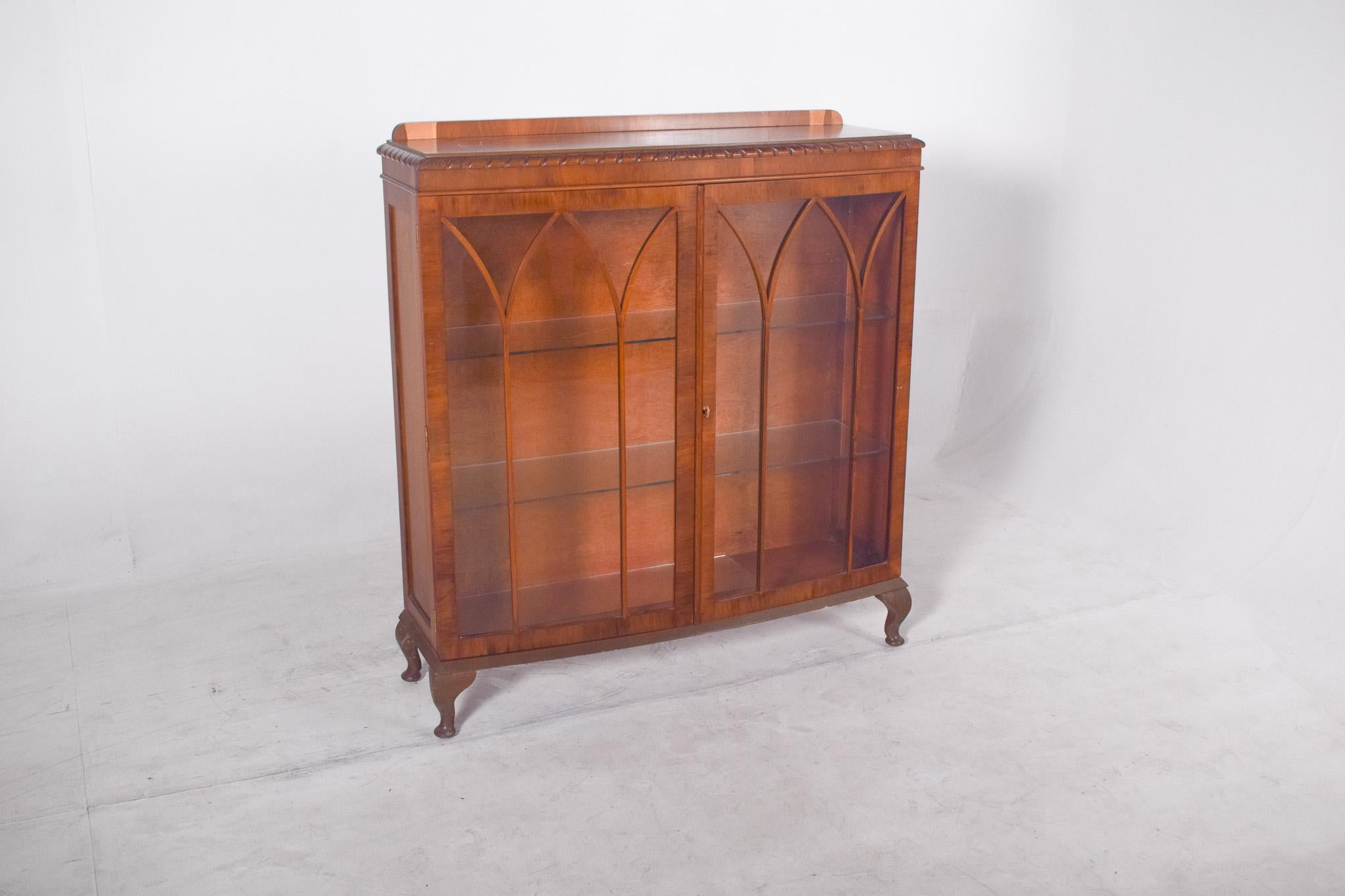 Double-door showcase in light wood. The glass doors are decorated with internal frames in the shape of ogival arches, a characteristic element of Gothic architecture reinterpreted here with delicacy and lightness
The top has a discreet carved edge