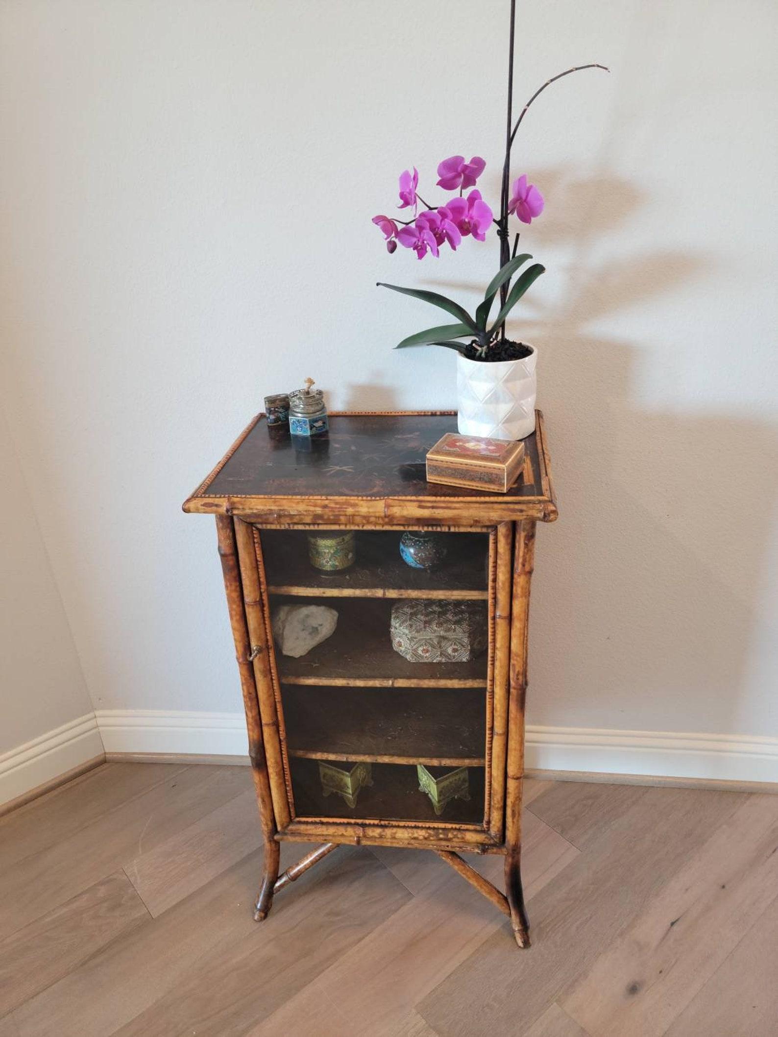 A charming late 19th century English Victorian Aesthetic Movement side cabinet.

Hand-crafted in exotic Oriental Chinoiserie taste, featuring attractive lightly scorched tiger bamboo, having a single glazed glass panel door opening to shelved