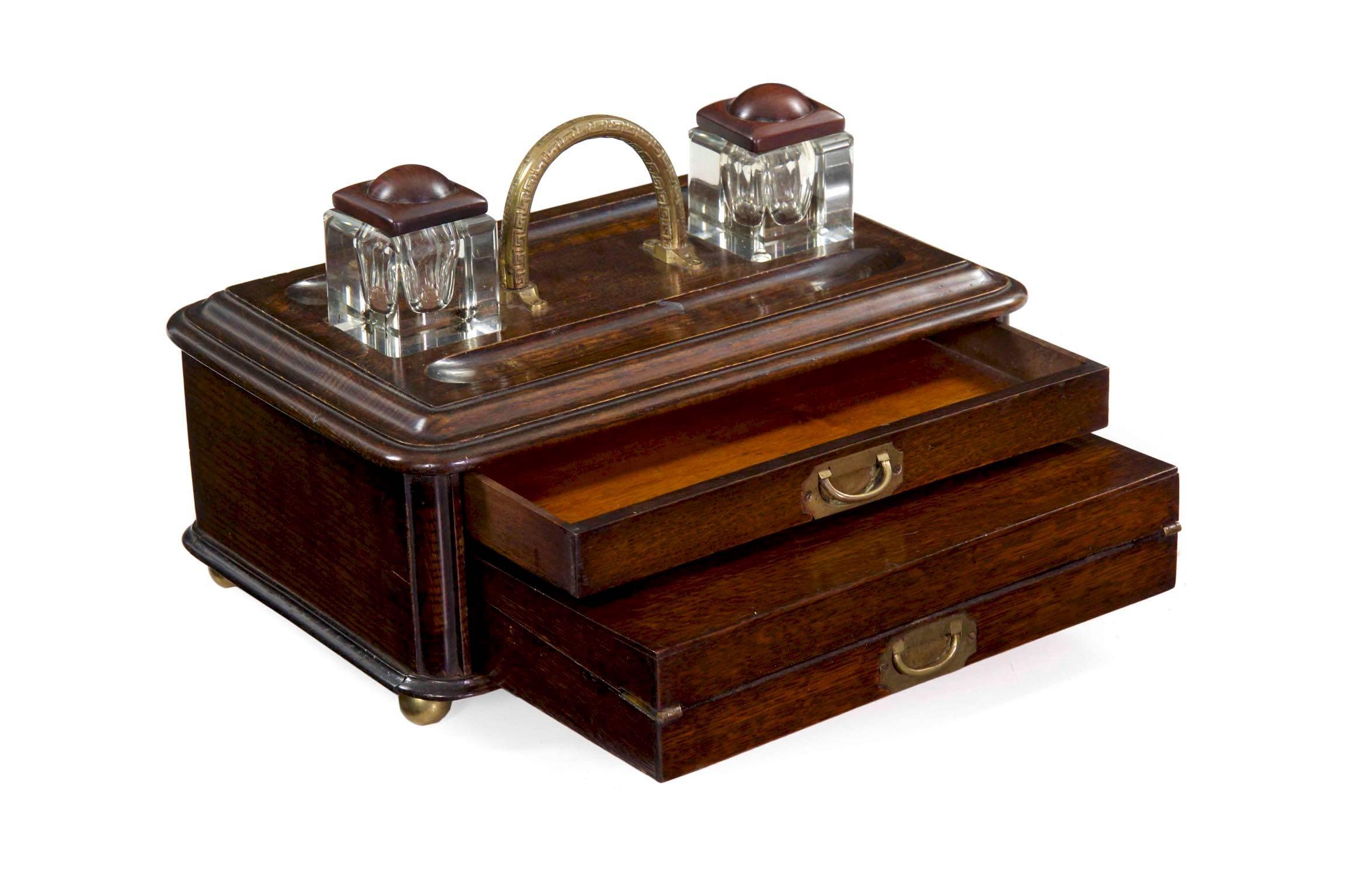An unusual and most attractive English writing box from the late Victorian period, the box is crafted of beautifully patinated and worn oak. The top has two recesses that cut glass wells rest within, these easily lifting free and portable, each with